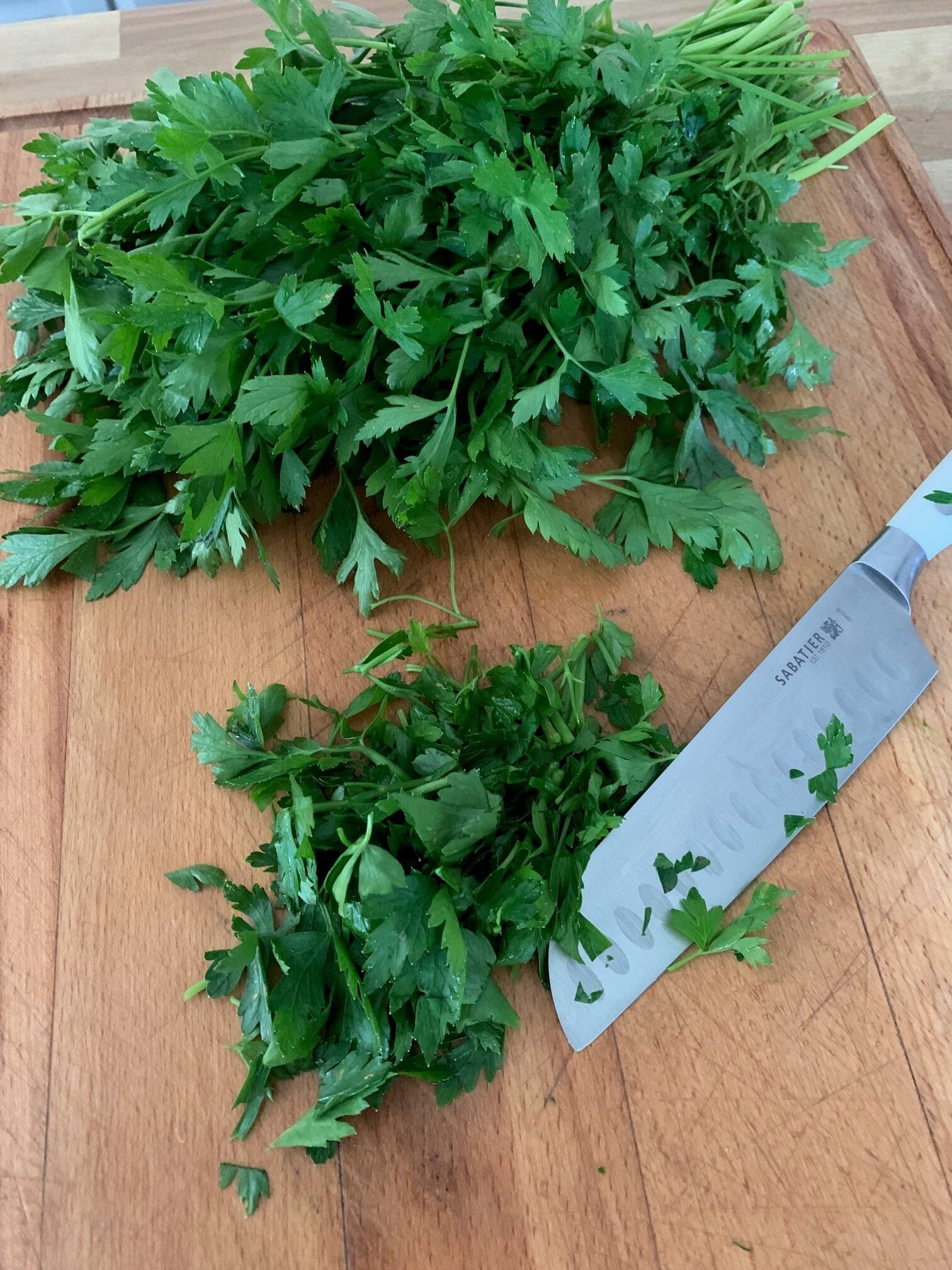 Cutting board with parsley and a knife. 