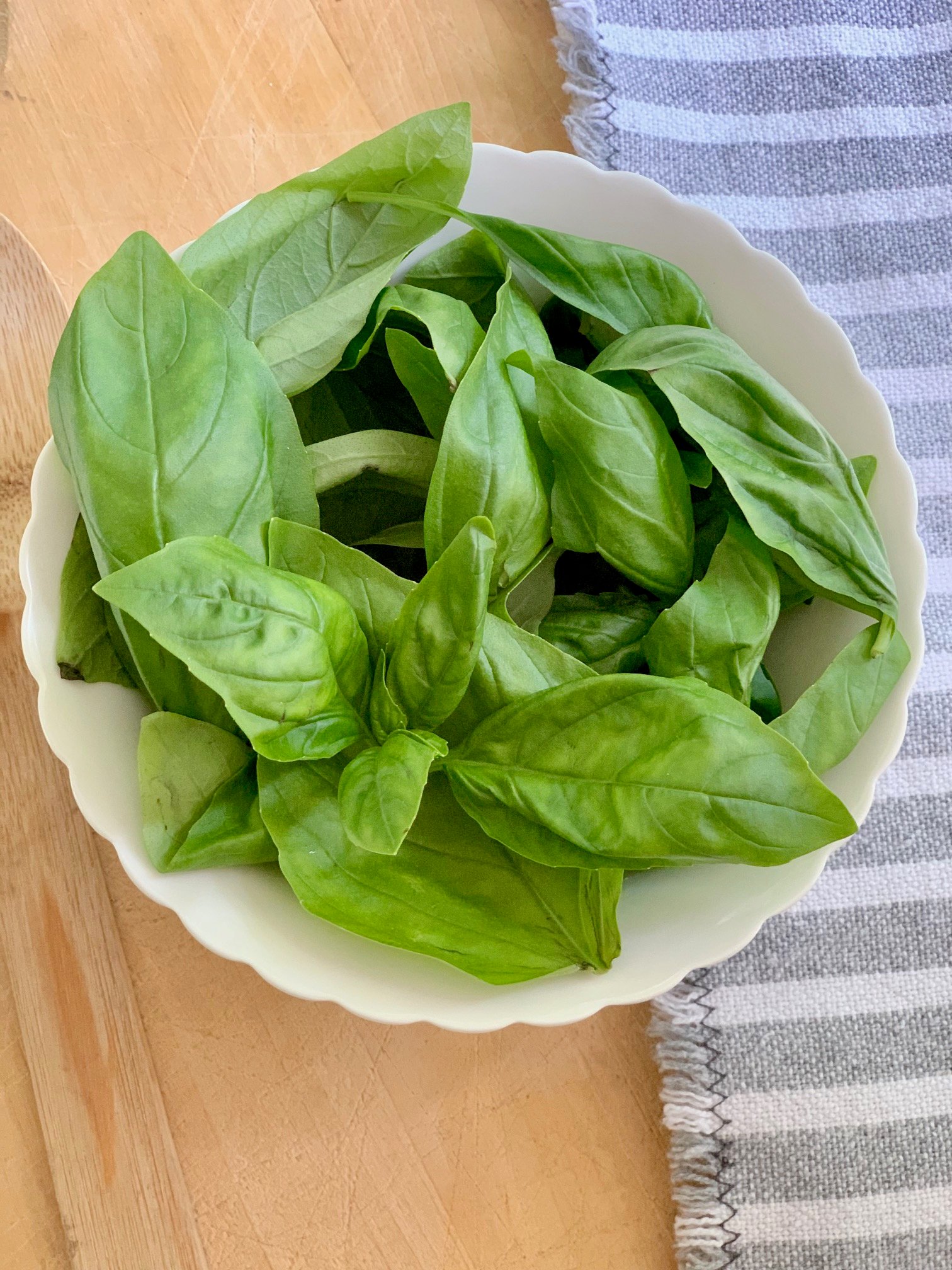 A bowl of fresh basil leaves. 