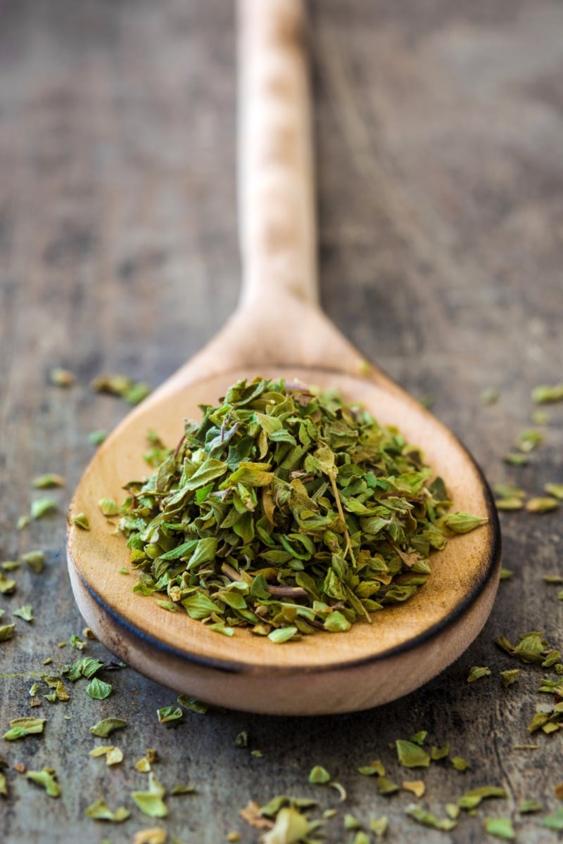 Large wooden spoon of dry oregano. 