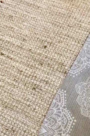 A jute rug with a grey low pile layered over it.