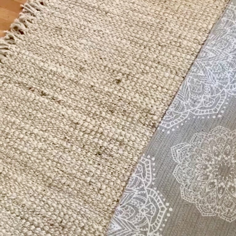 A jute rug with a grey low pile layered over it.