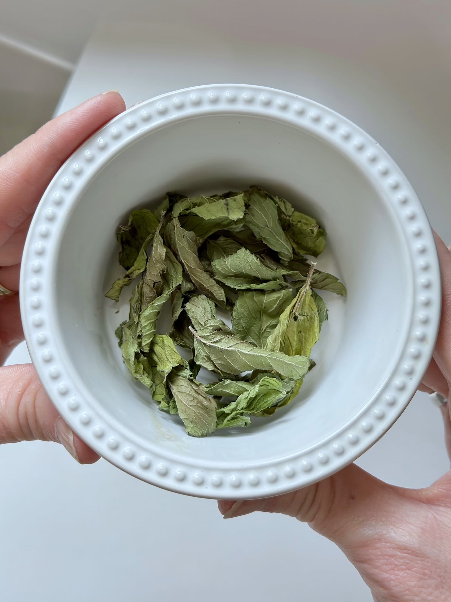 Dried leaves removed from the stem in a bowl.