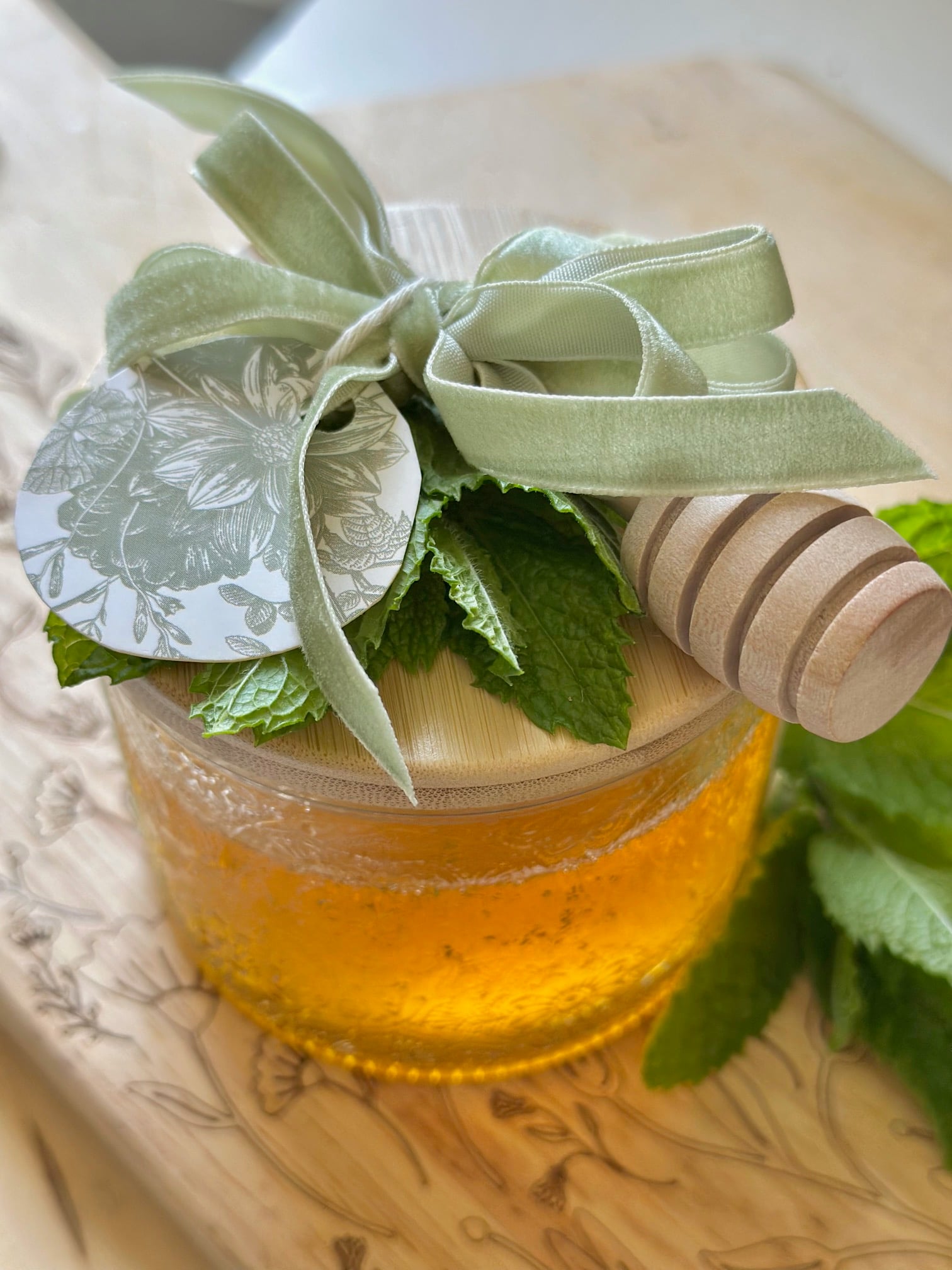 Mint honey in a pretty jar with a bow, honey wand and a gift tag. 