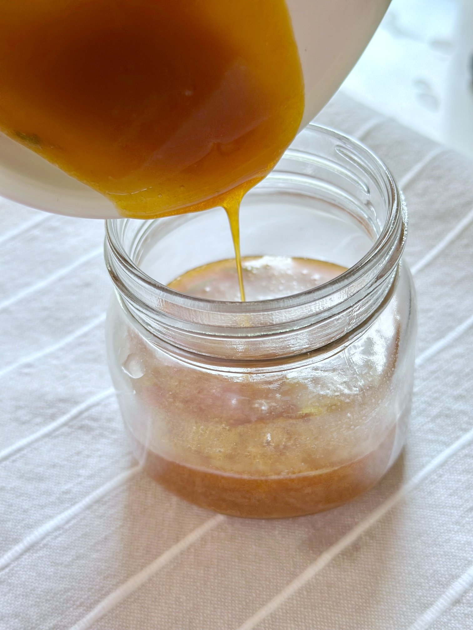 Pouring the infused honey in the jar. 