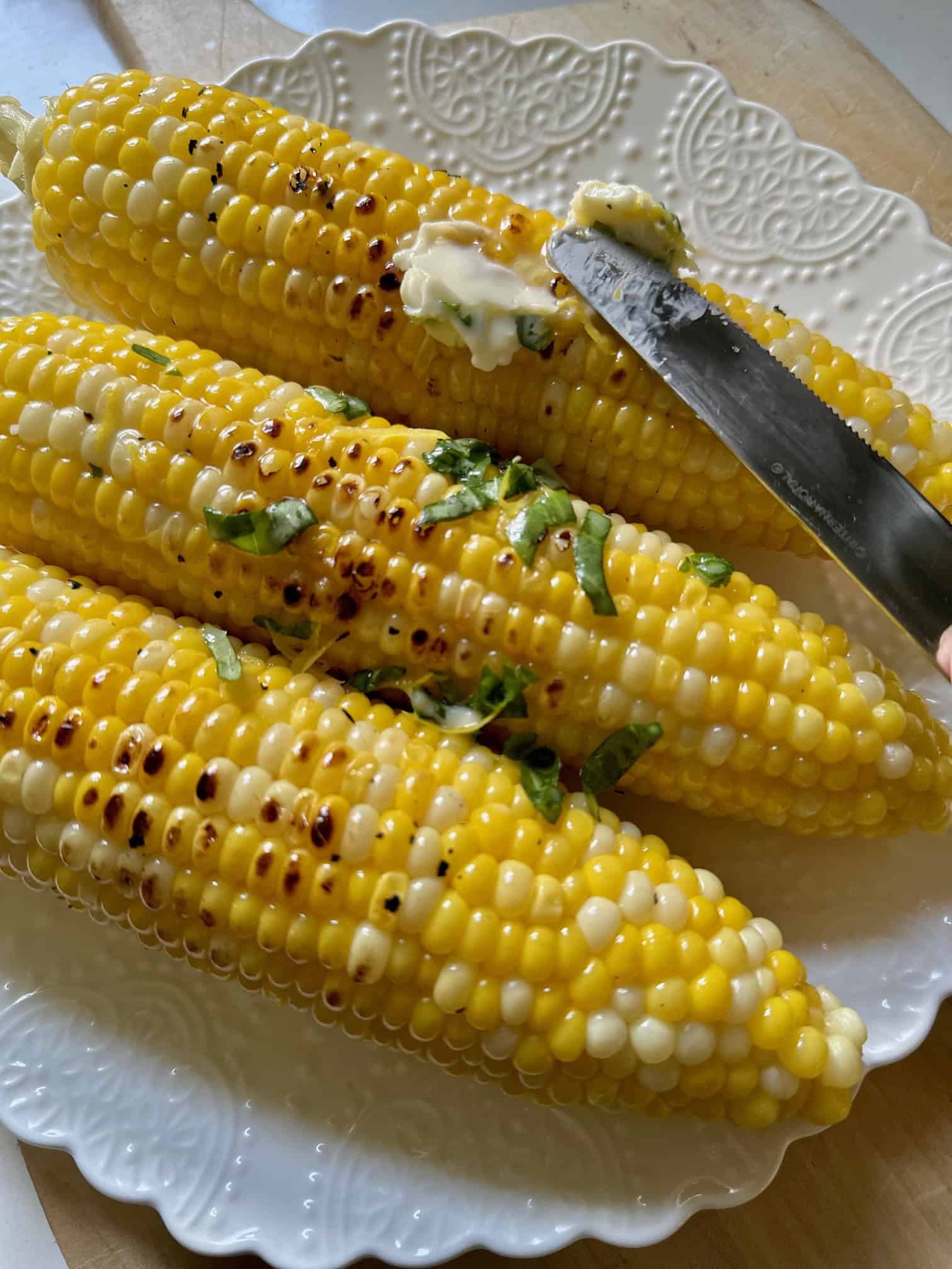 Spreading butter on corn on the cob.