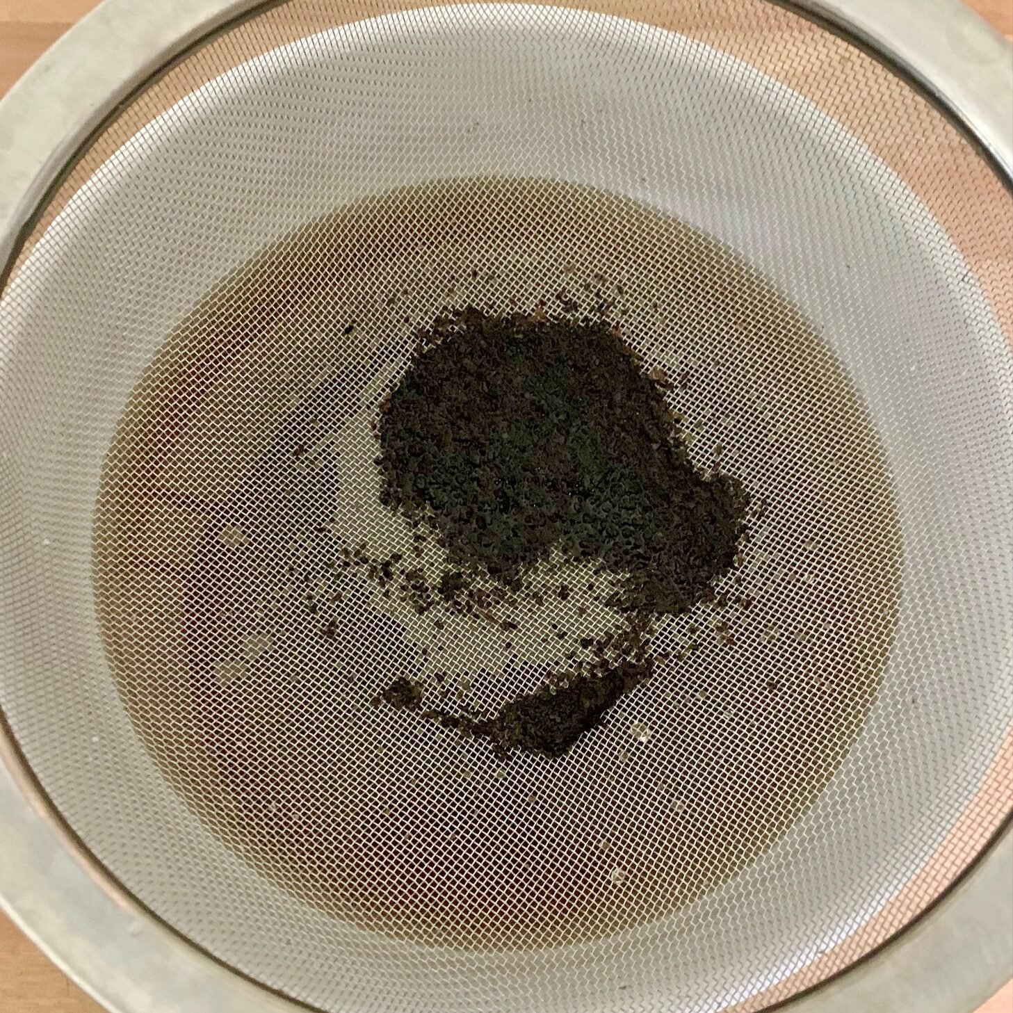 Coffee grounds in strainer.