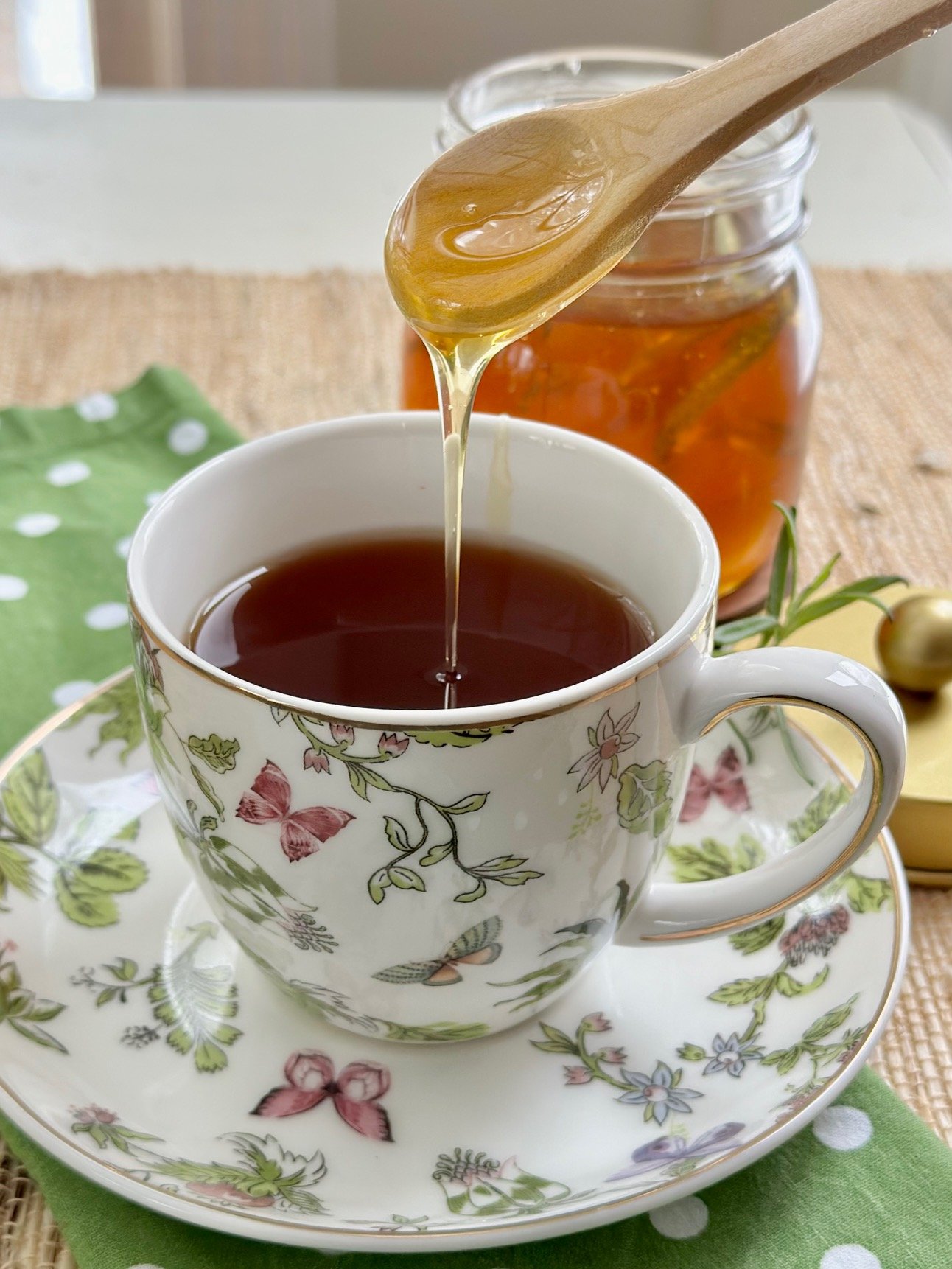 Honey in tea in a floral tea cup.