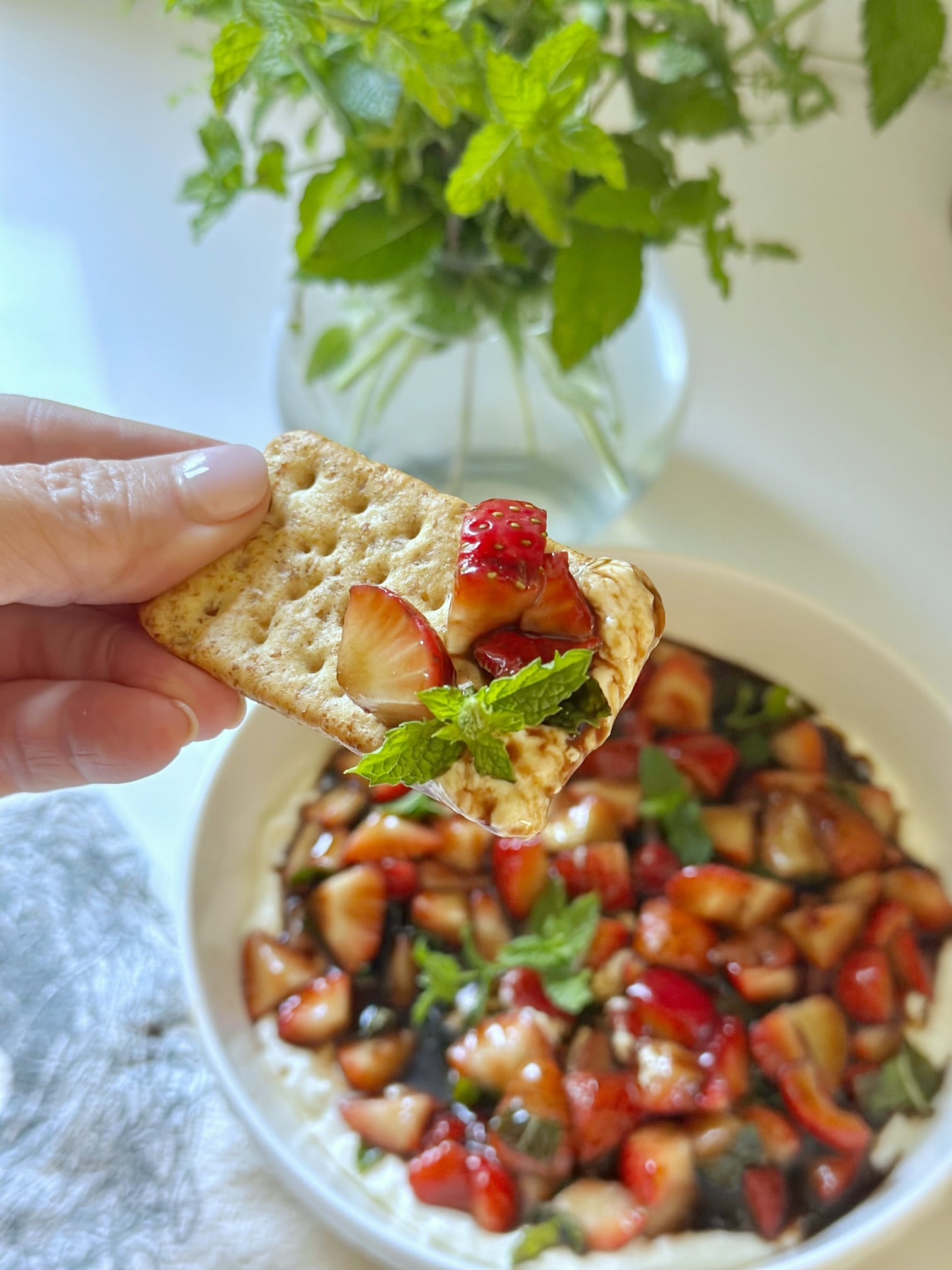 A cracker with strawberry mint bruschetta dip on it. 