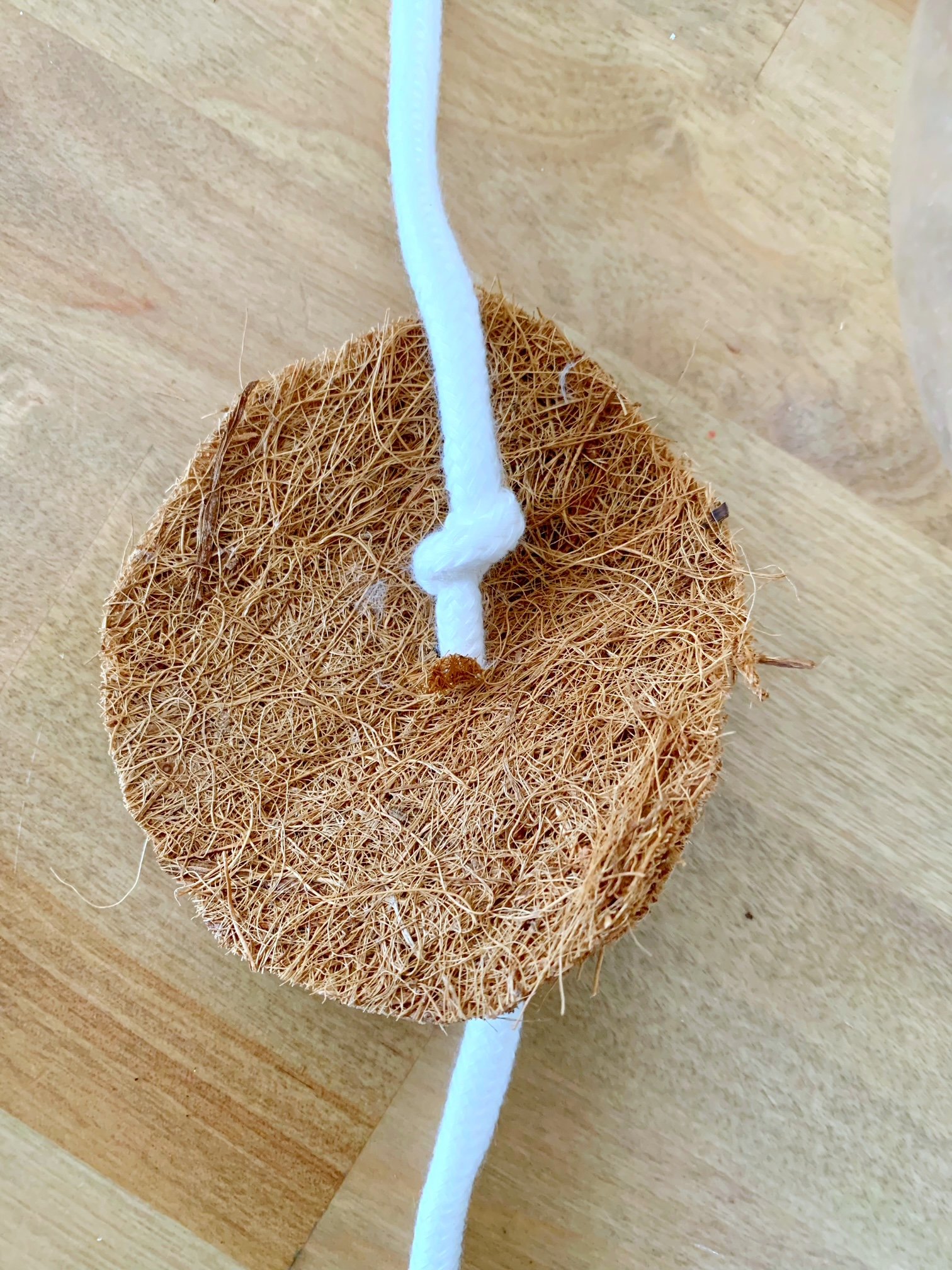 Push the wick through the hole and tie a knot.