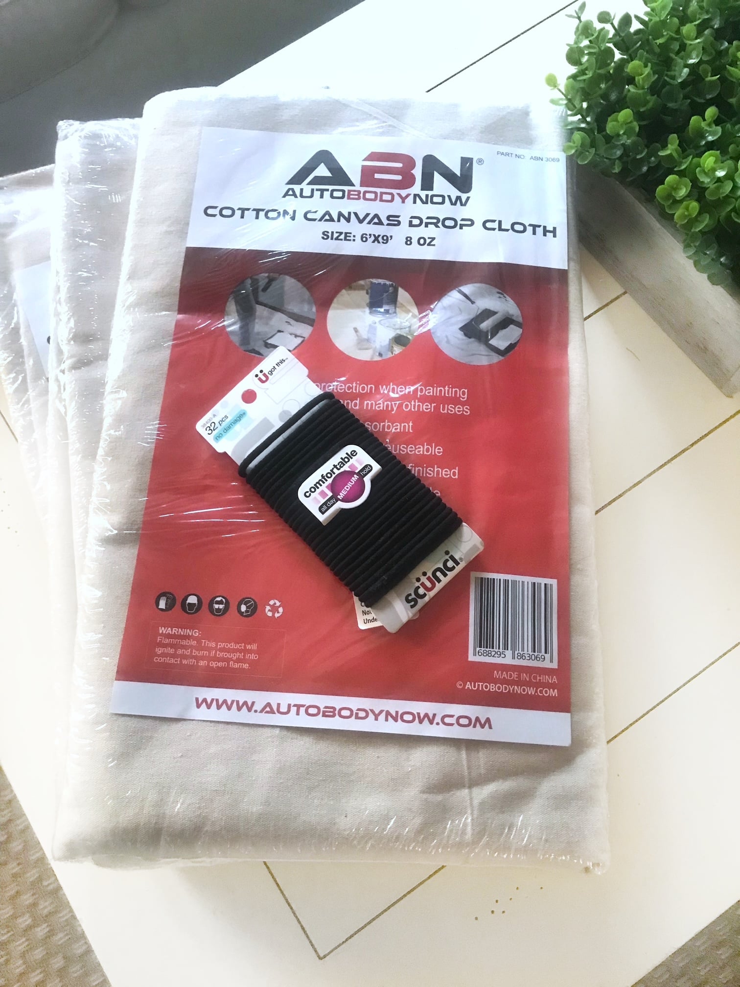 Drop cloths in their package with some Scunci black hair ties.