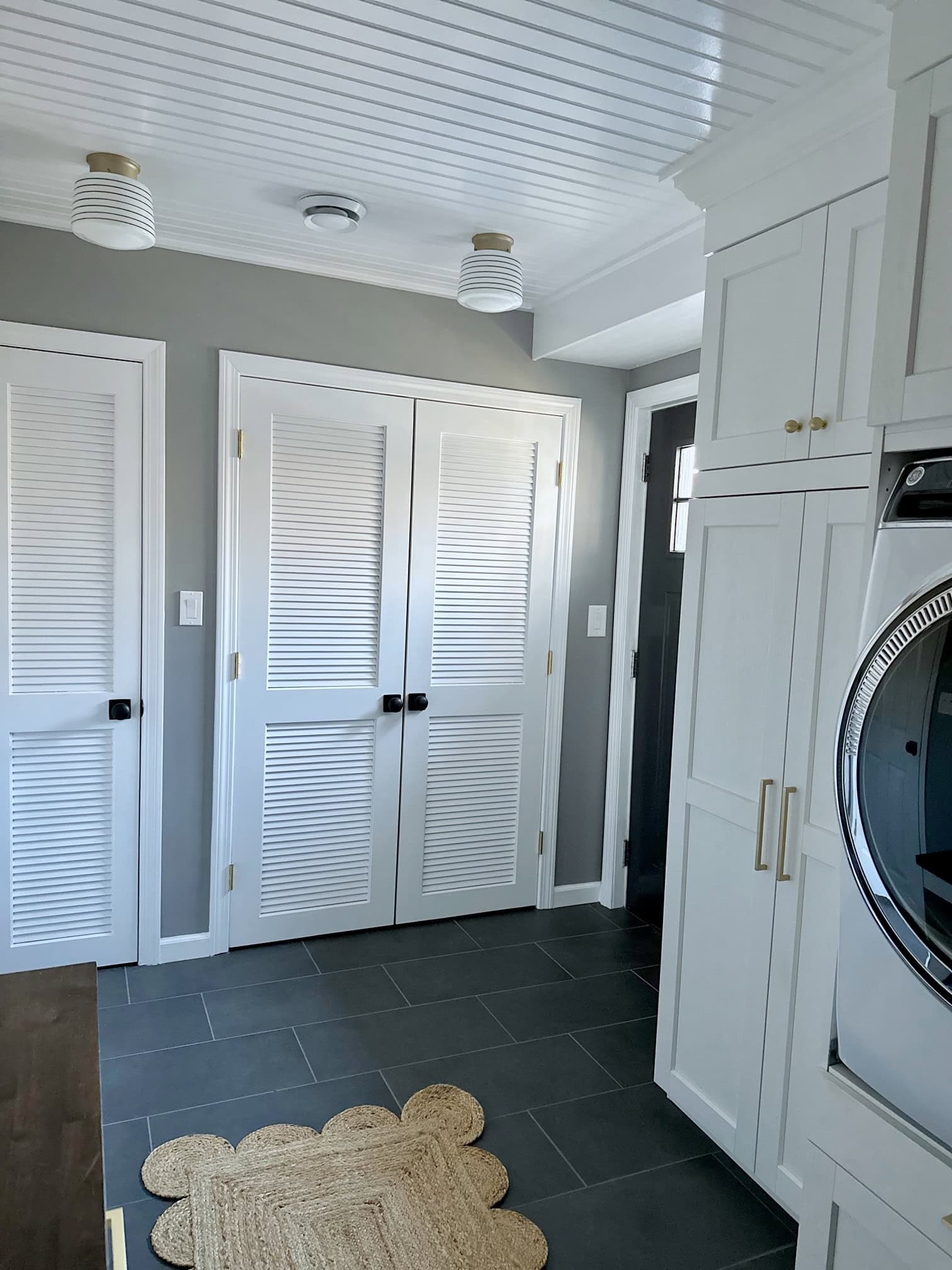 The other side of the laundry room that shows the flooring, door and trim. 