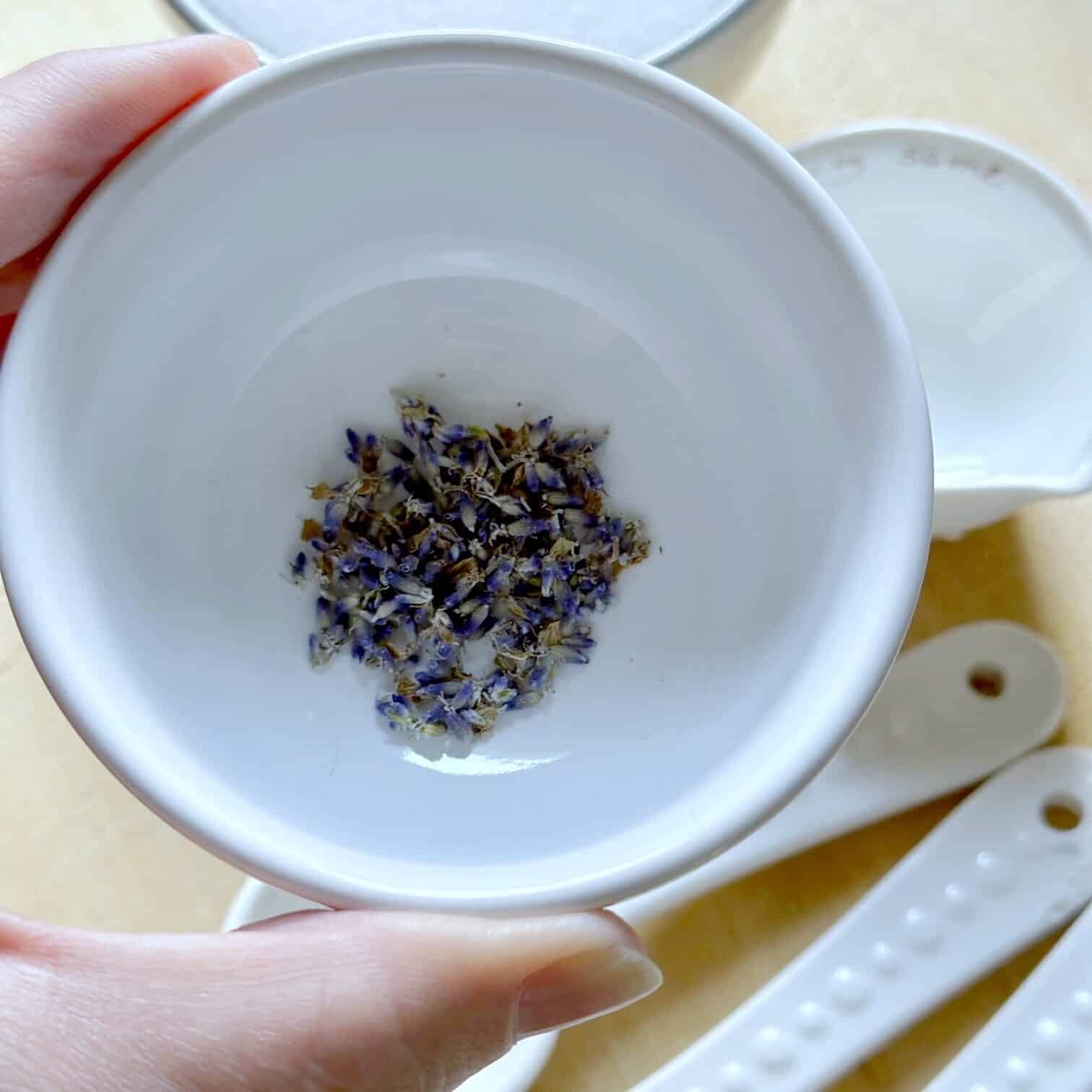 Small white bowl of fresh lavender buds. 