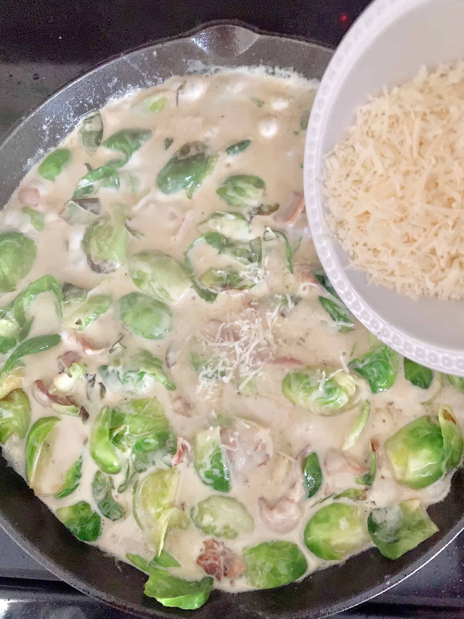 Adding parmesan cheese to the top. 