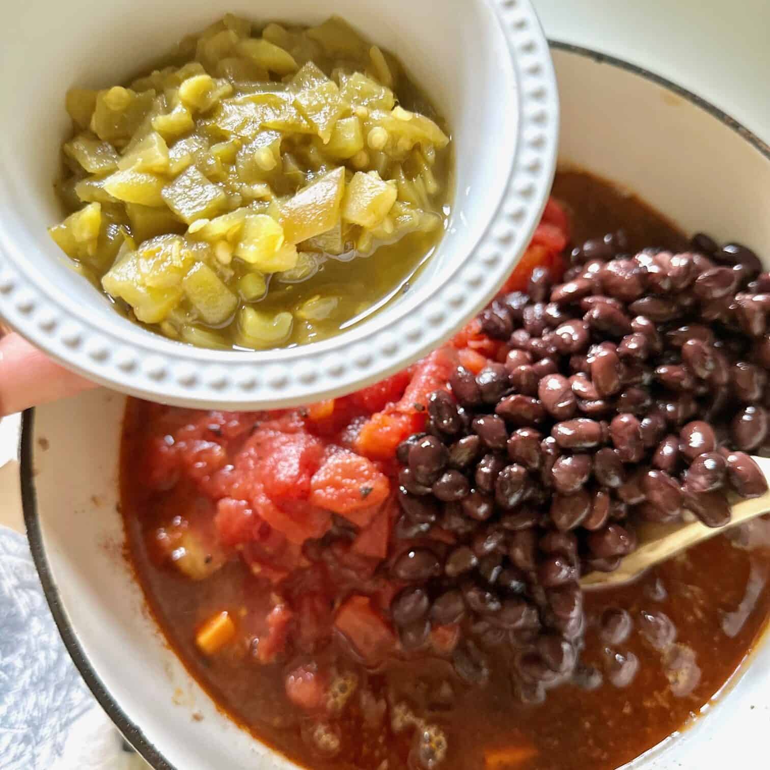 Broth, beans, tomatoes and chilies in the pot. 