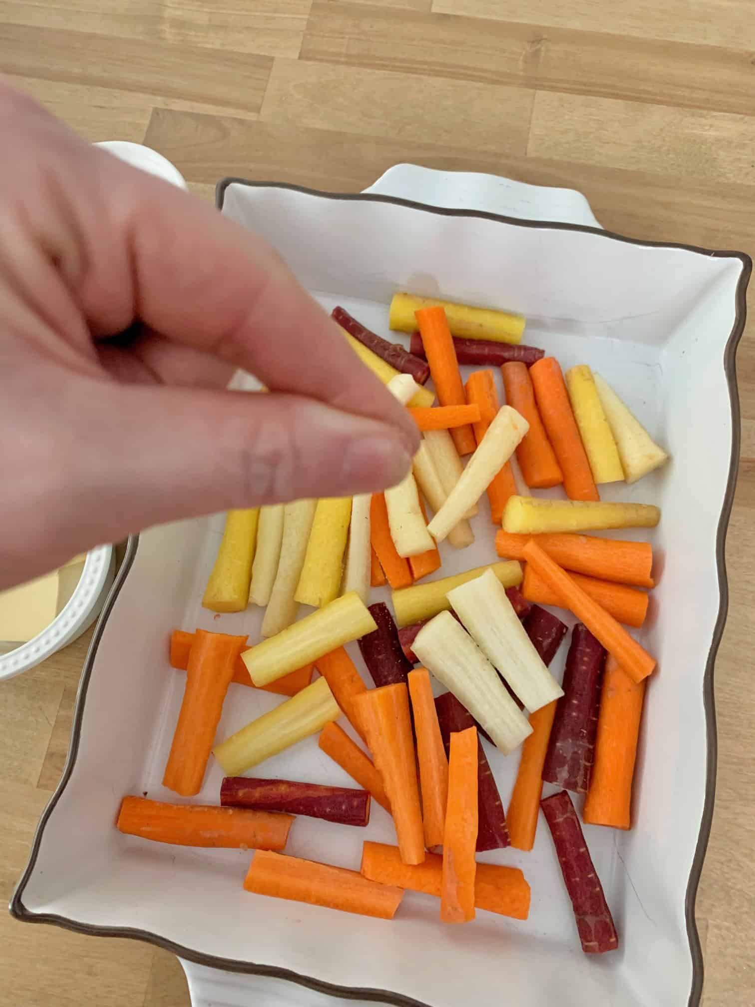 Adding a pinch of salt to cut carrots. 