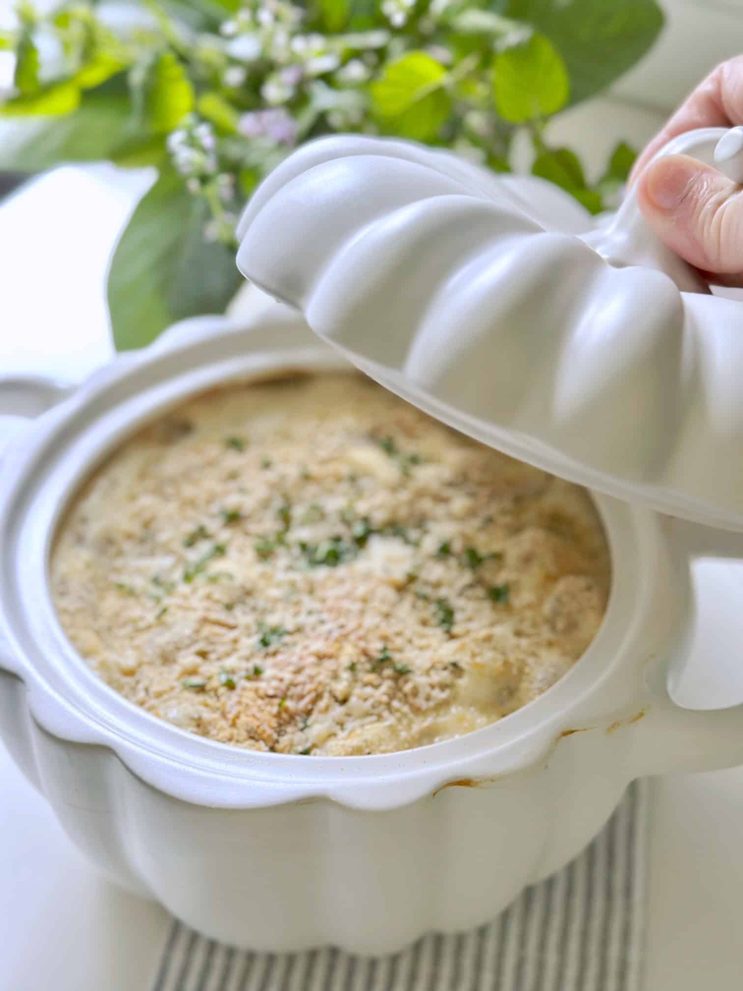 A white pumpkin casserole dish filled with yummy creamed onions. 
