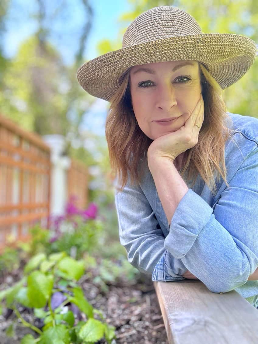 Me leaning on my herb bed.