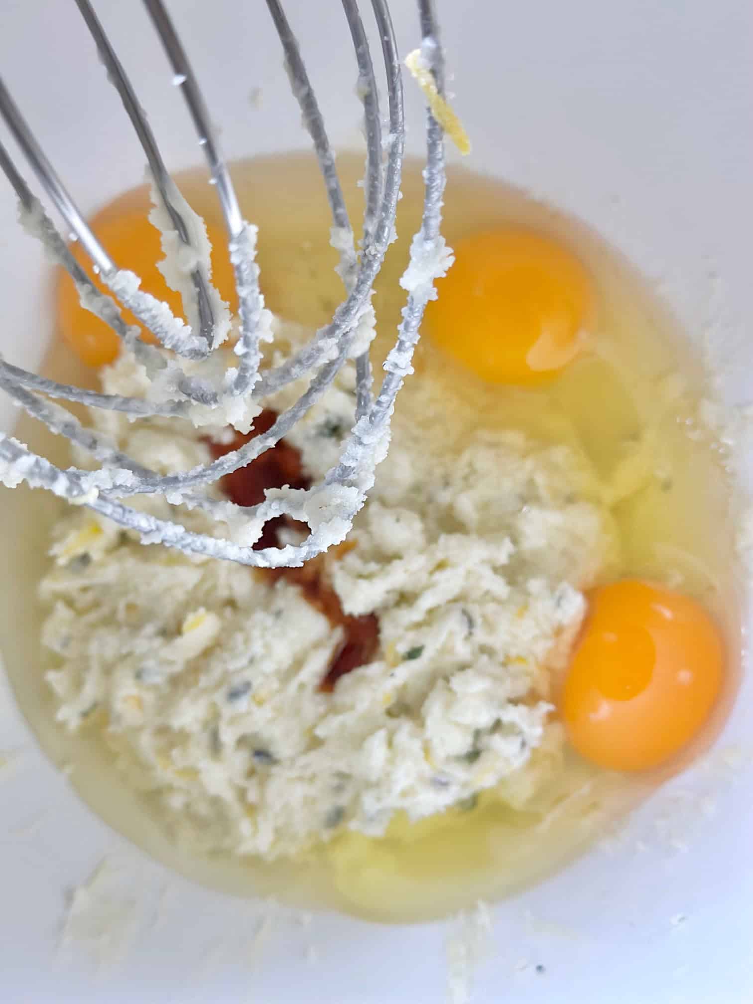 Adding eggs to the creamed butter and sugar.