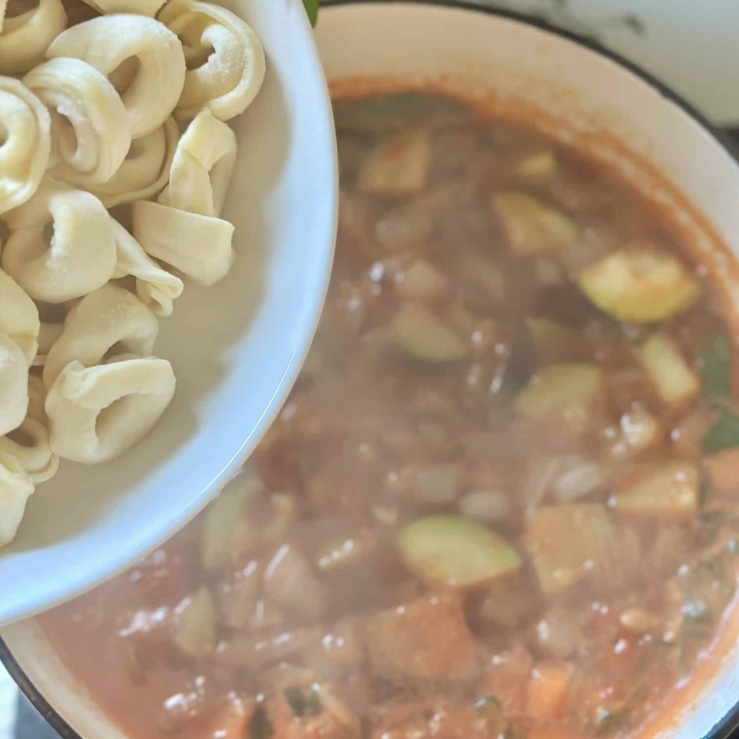 Adding the tortellini to the soup. 