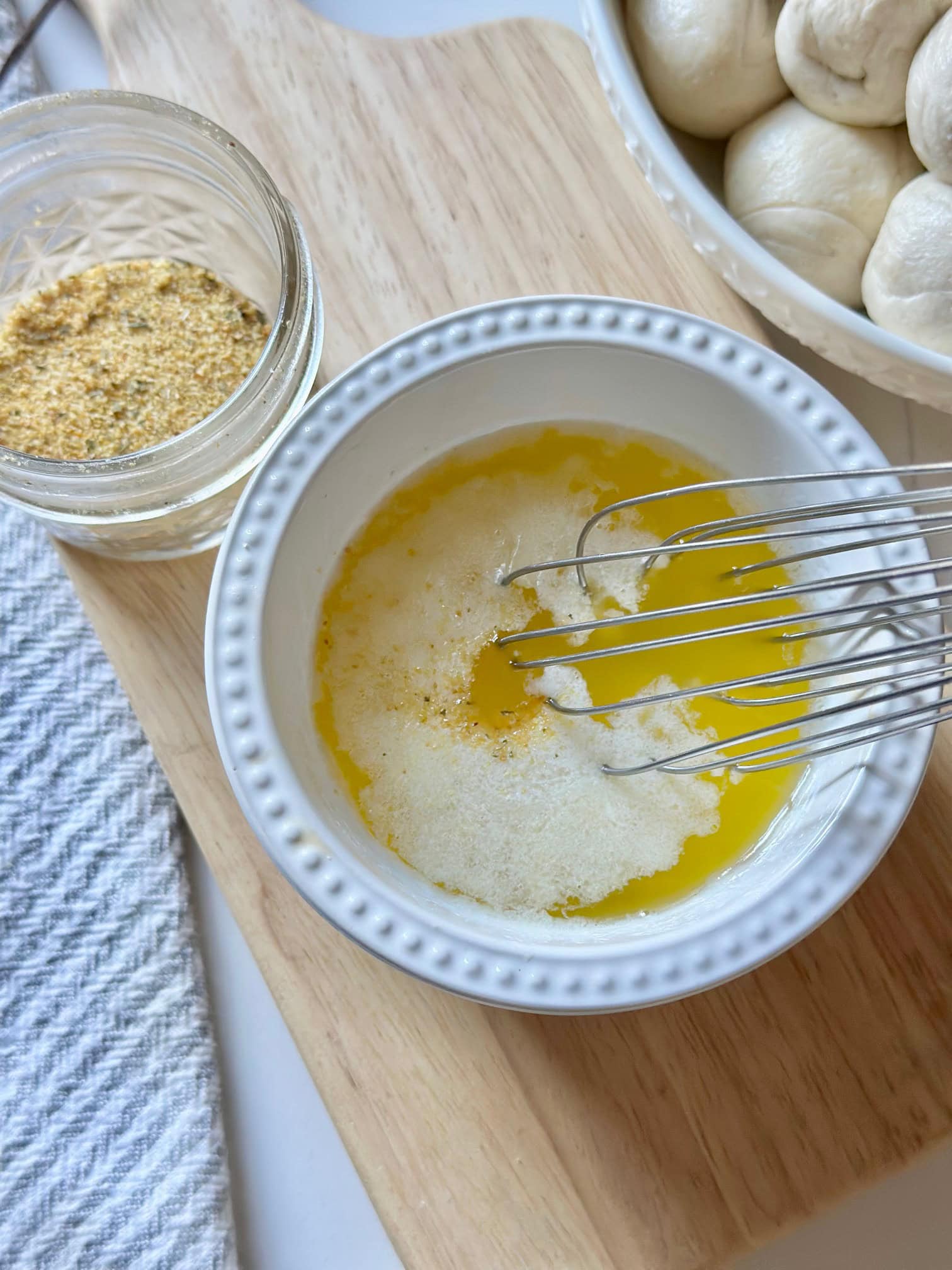 Mixing melted butter and garlic powder.