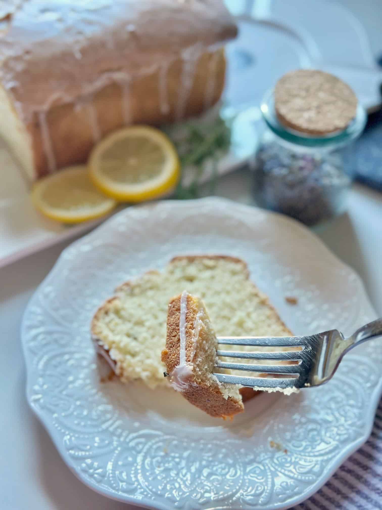 A slice of this lemon lavender pound cake on a plate with a fork.