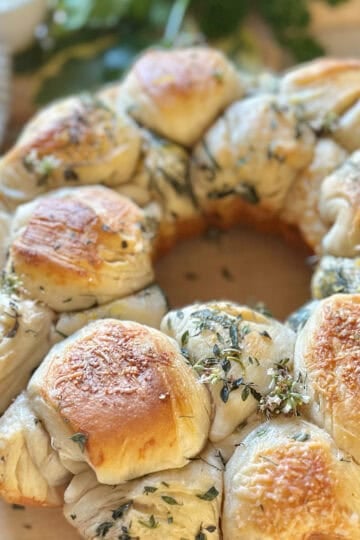 Fresh herb pull apart bread on a cutting board.