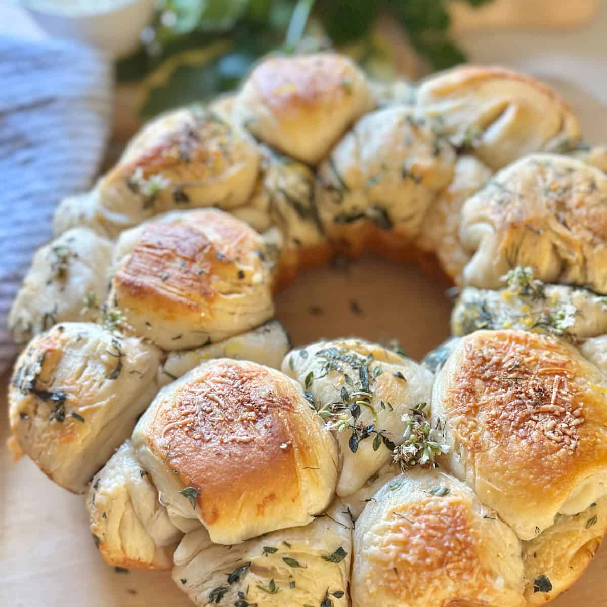 Fresh herb pull apart bread on a cutting board.