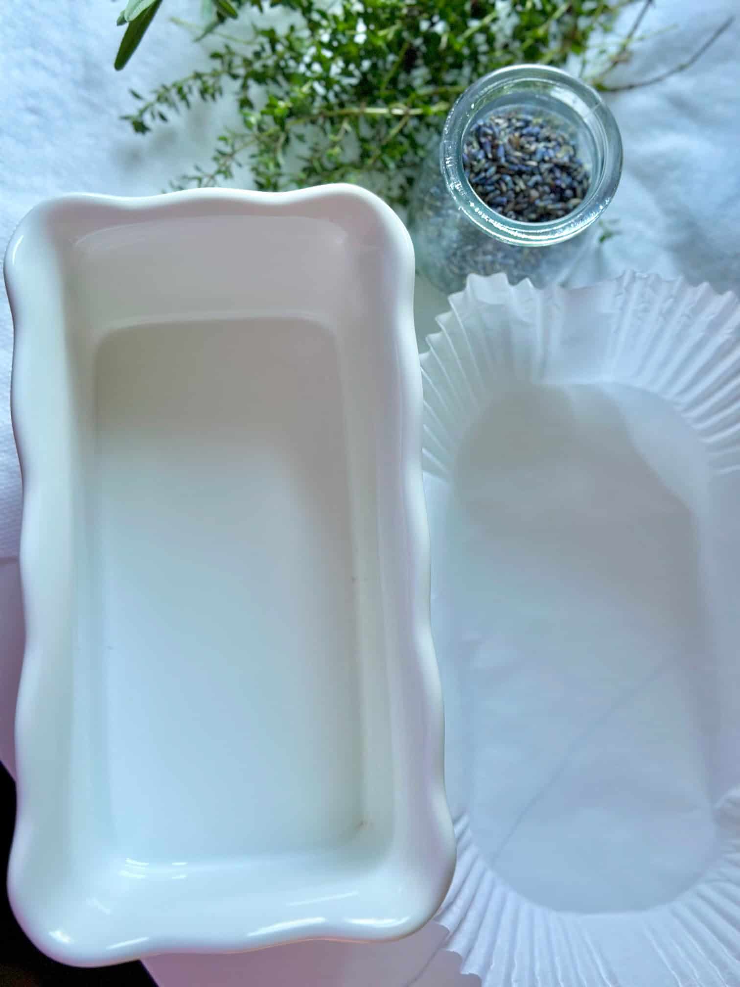 A loaf pan with a parchment loaf pan liner next to it.