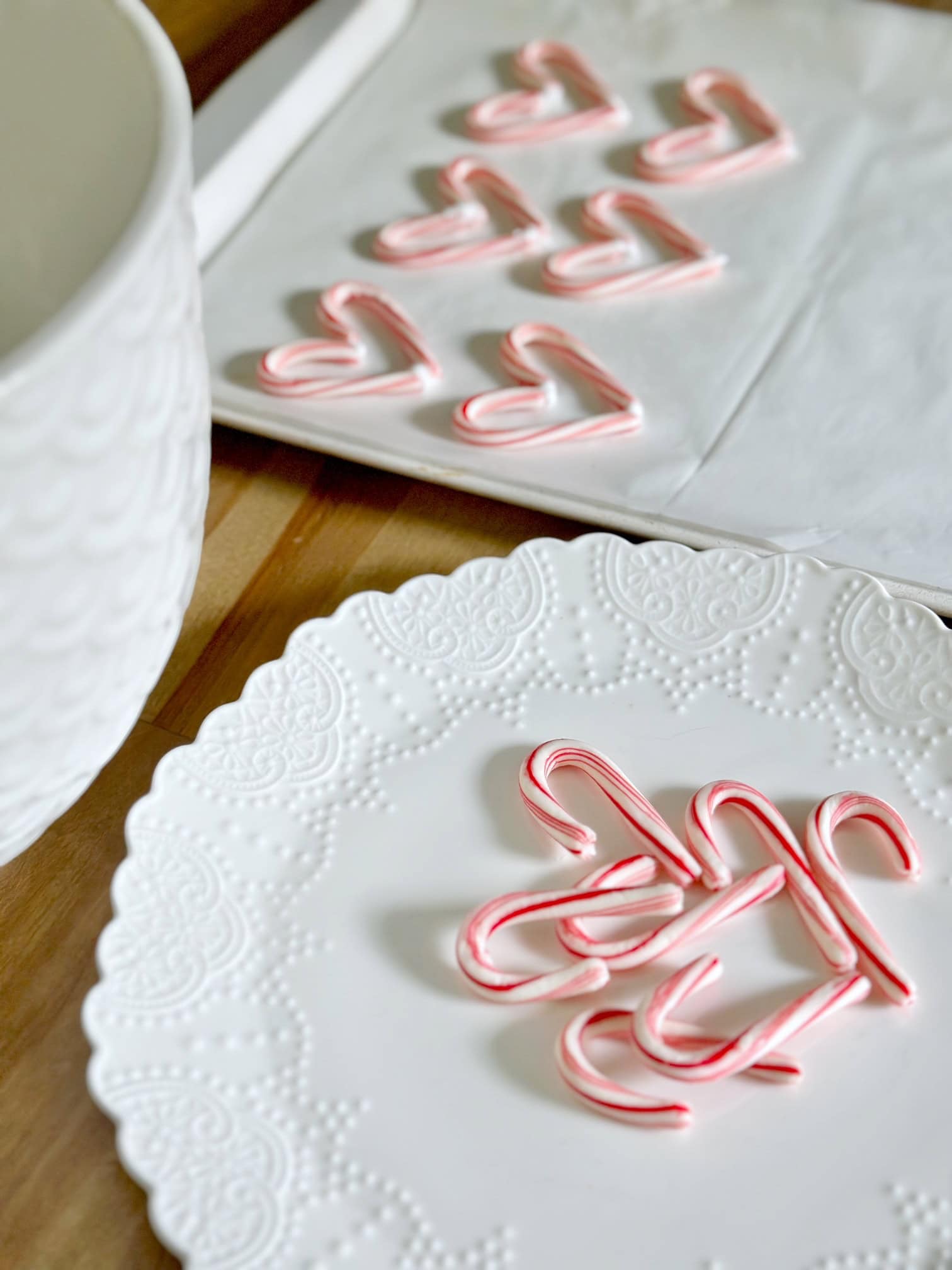 Candy canes on a plate with hearts in the background. 