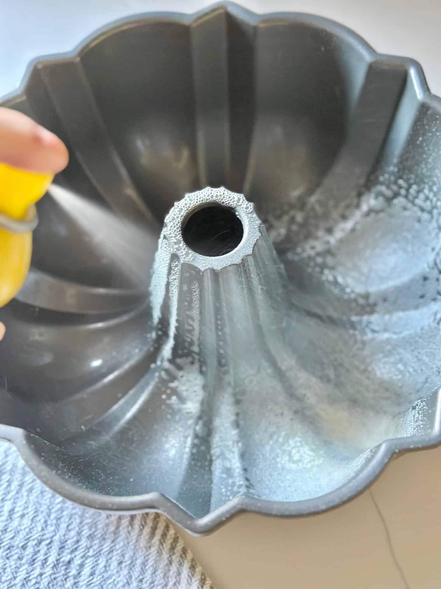 Bundt pan being sprayed with Pam Cooking Spray.
