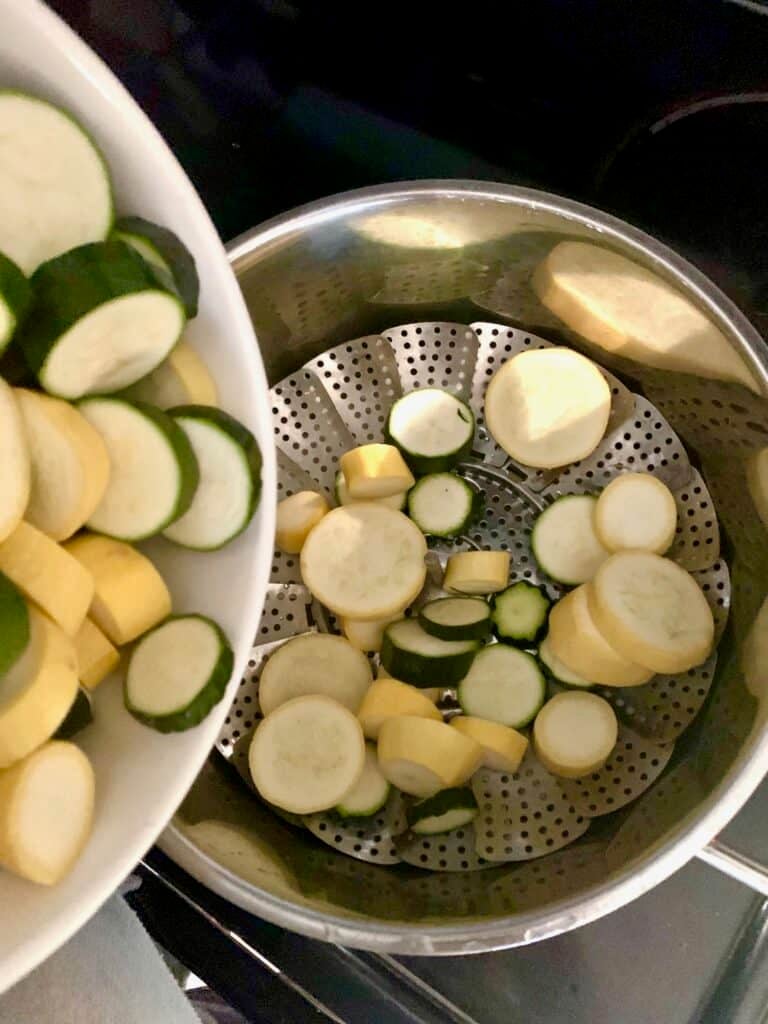 Placing the squash rounds on a stem basket in a large pot. 