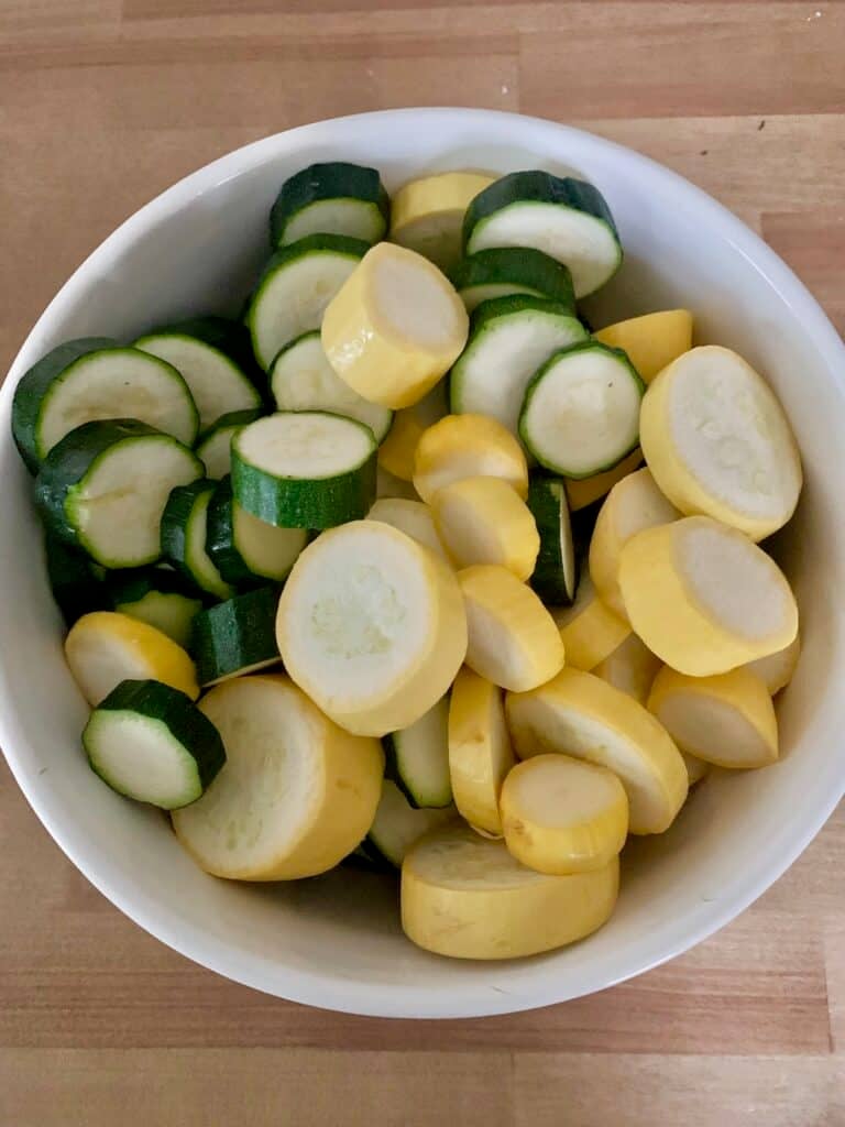 A large bowl of squash cut in rounds.