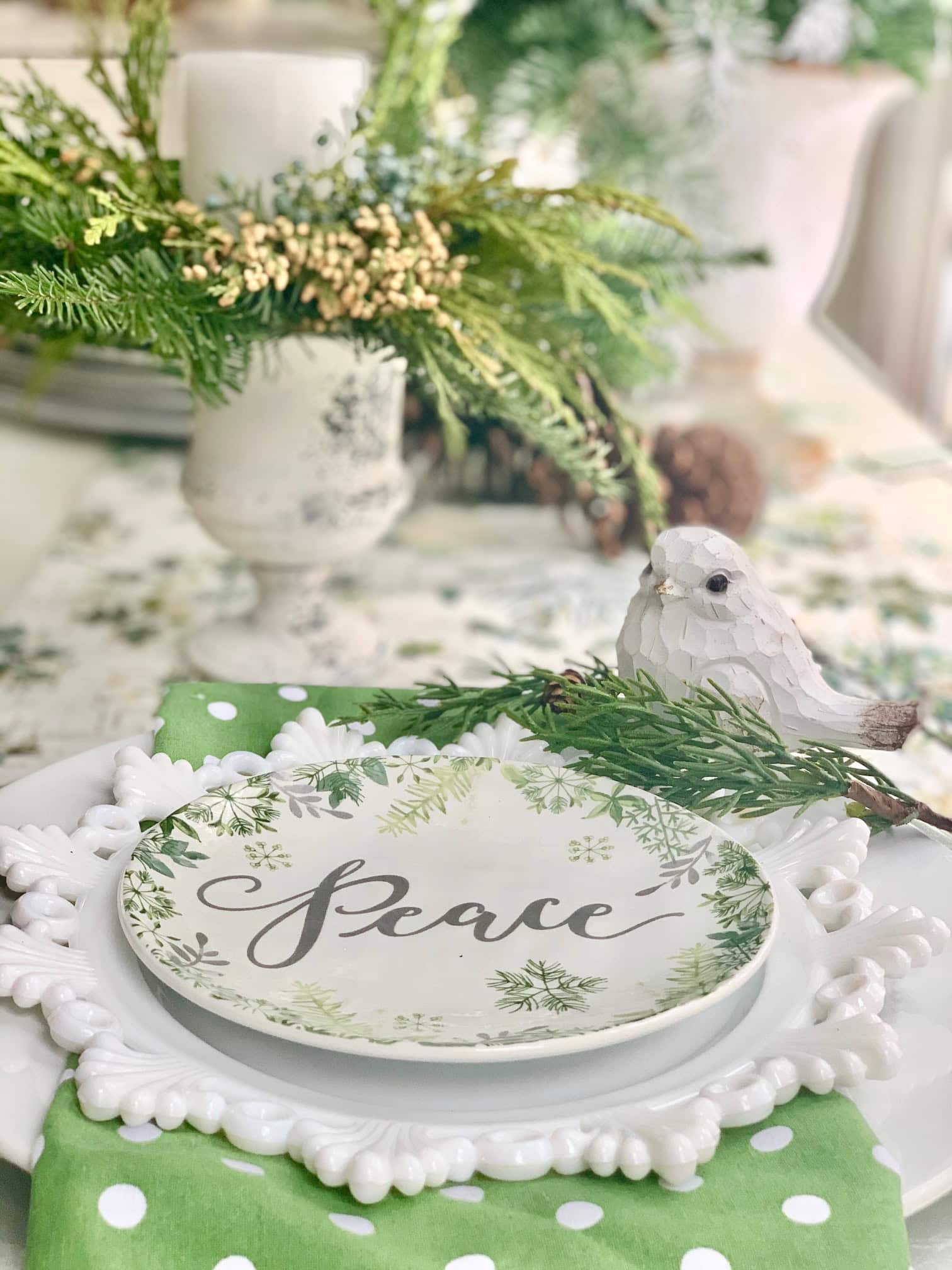 A vintage themed Holiday placesetting with a pretty milk glass salad plate. There's a little white bird at the setting.