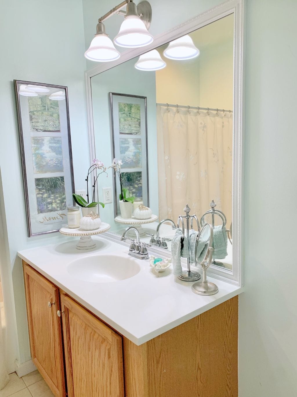 The after photo with a white frame around the mirror.