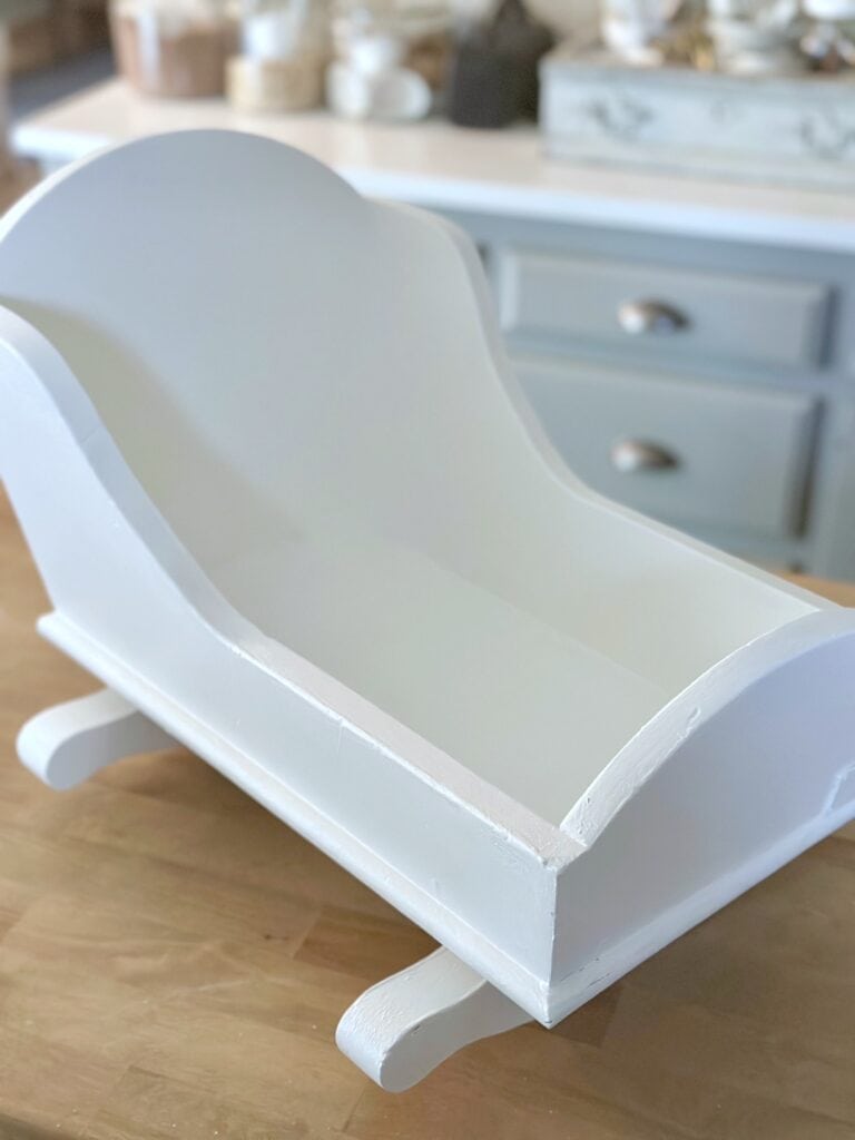 A thrifted cradle painted white. 