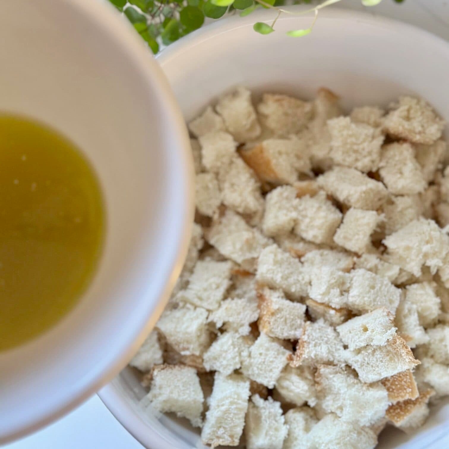 Adding butter mixture to croutons. 
