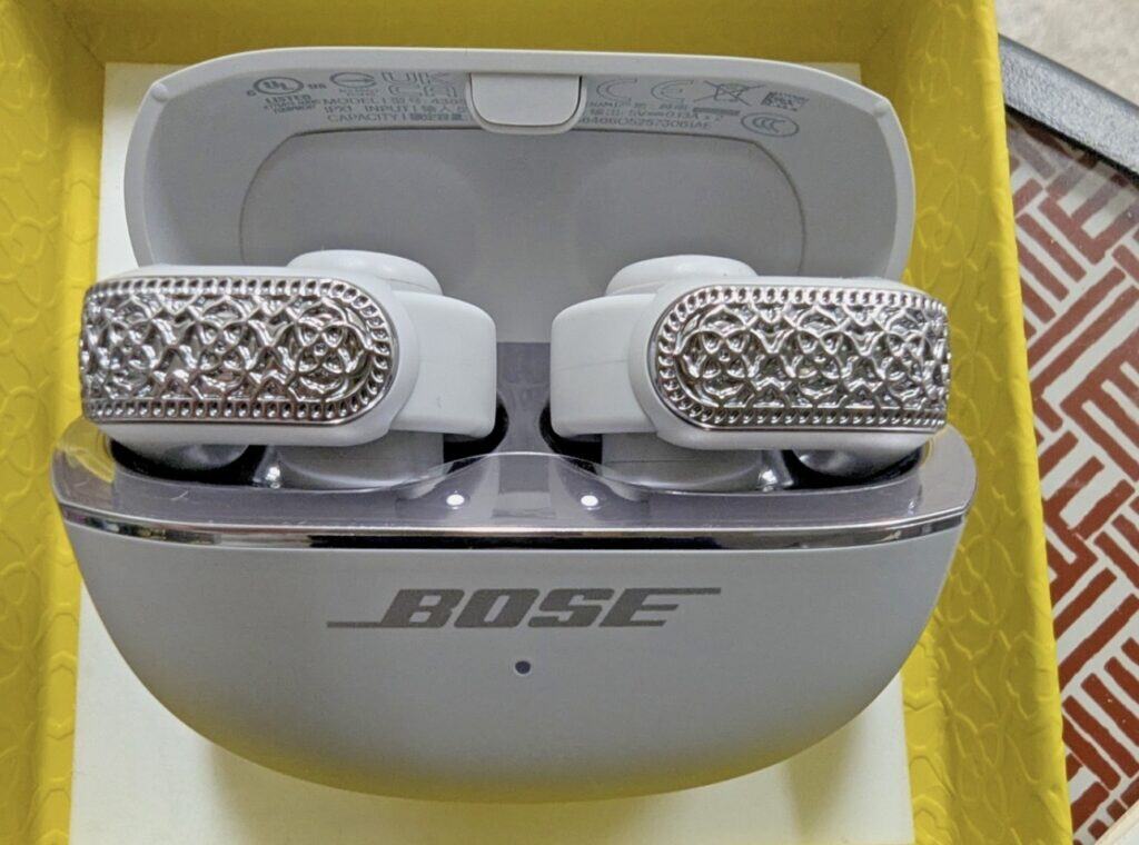 Bose open ear buds with silver embossed edges. 