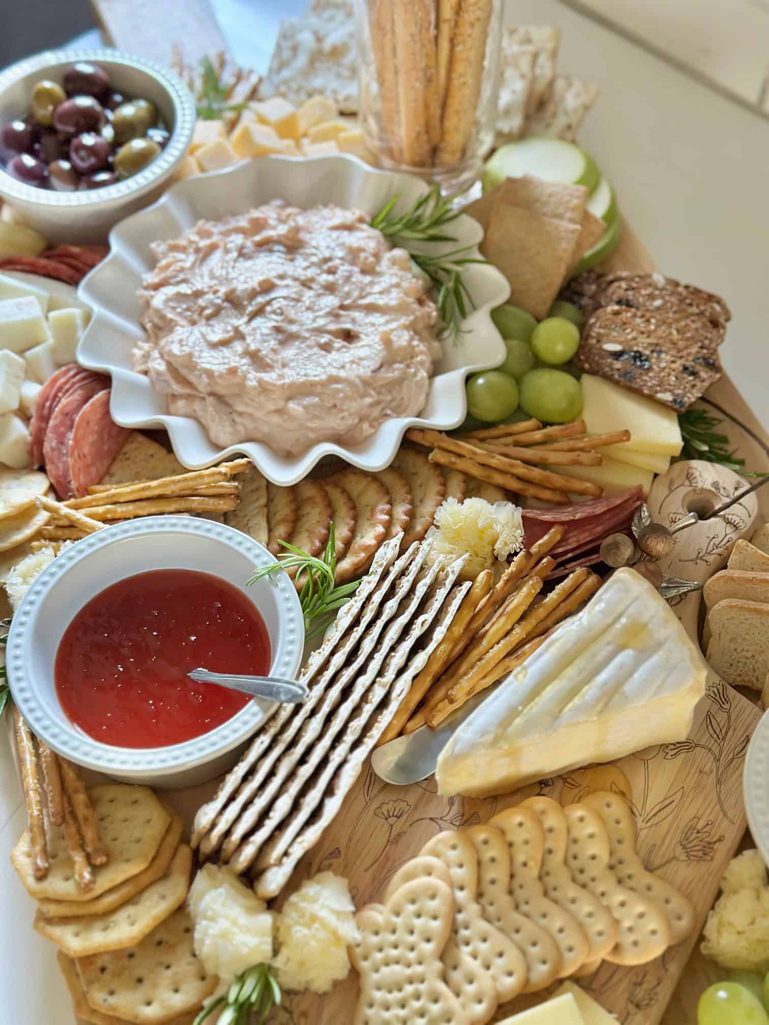 A big charcuterie board with small bowls. 