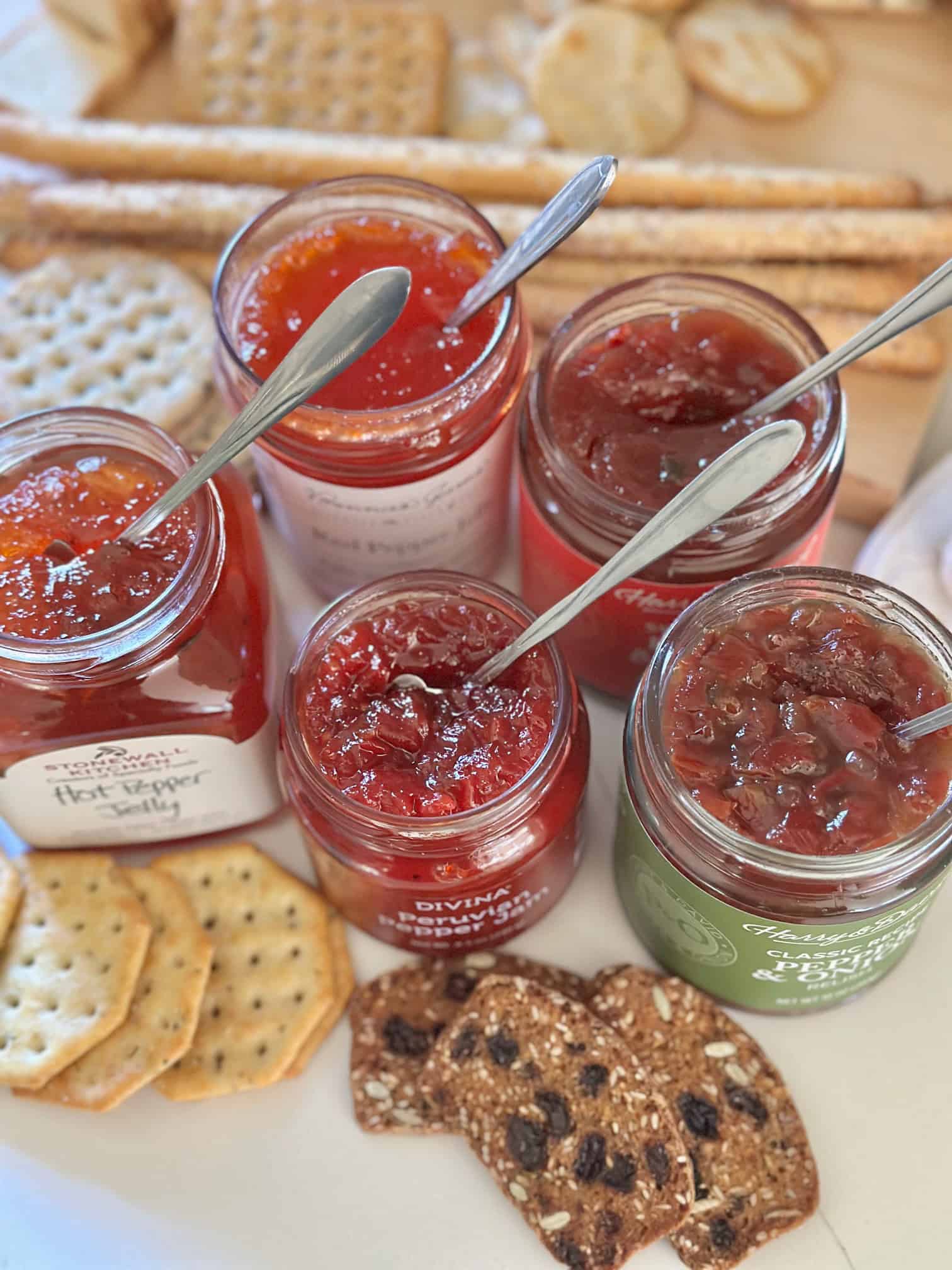 5 types of pepper jelly, jars open with little spoons. 