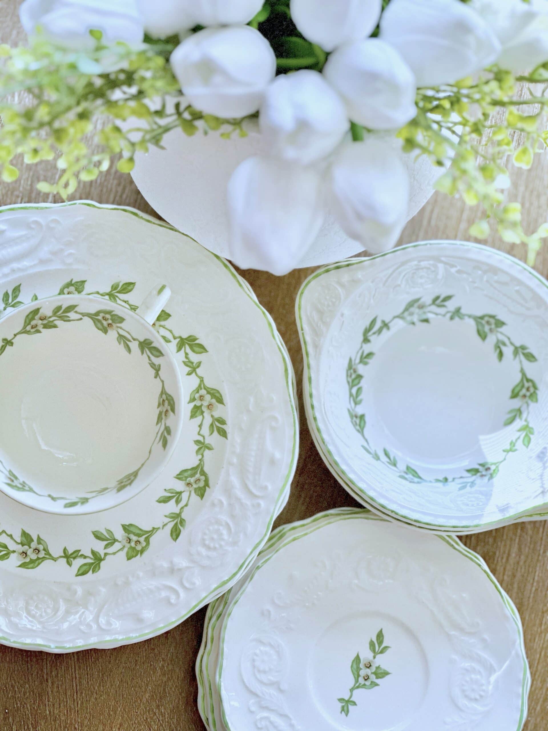 Vintage plates with green leaves and apple blossoms. 