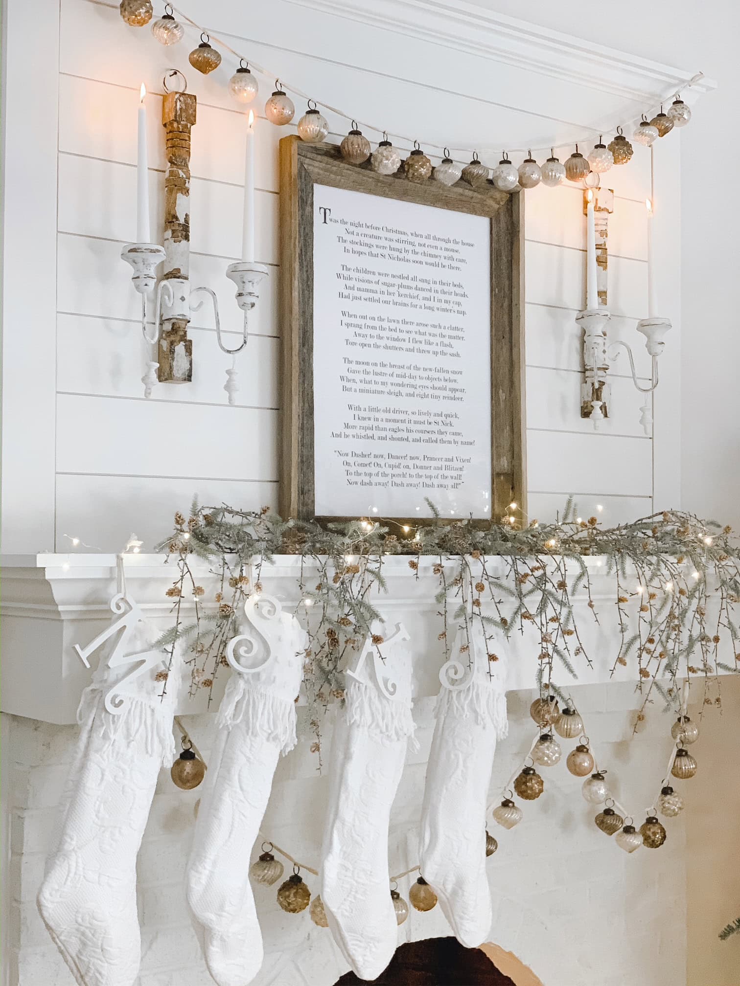 Mantel display with vintage wall sconces featuring taper candles. 