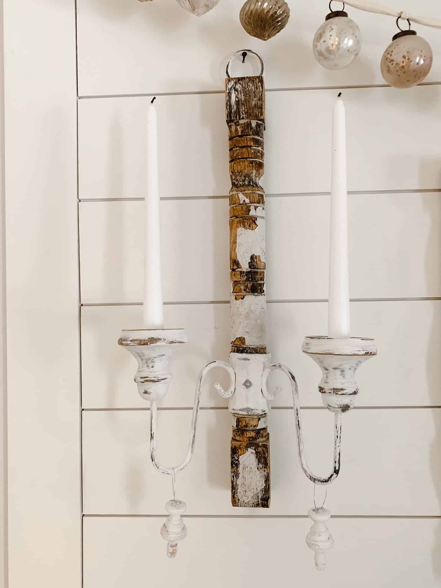 A candle wall sconce made with vintage items. 