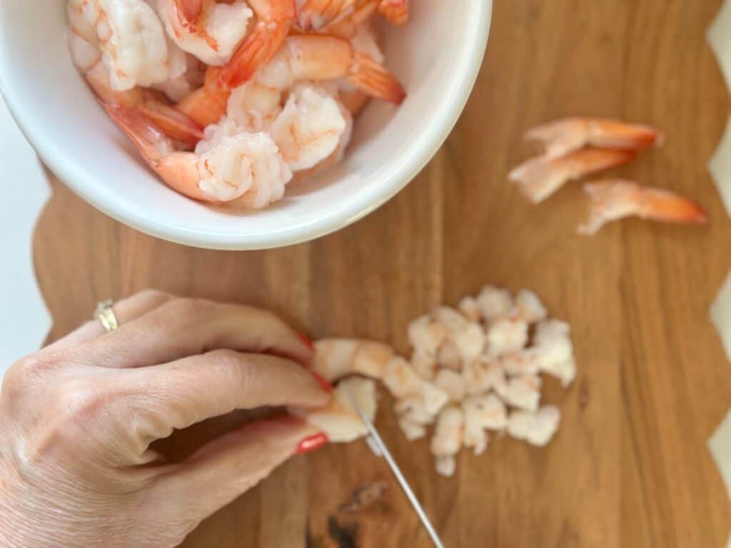 Chopping shrimp into small pieces.