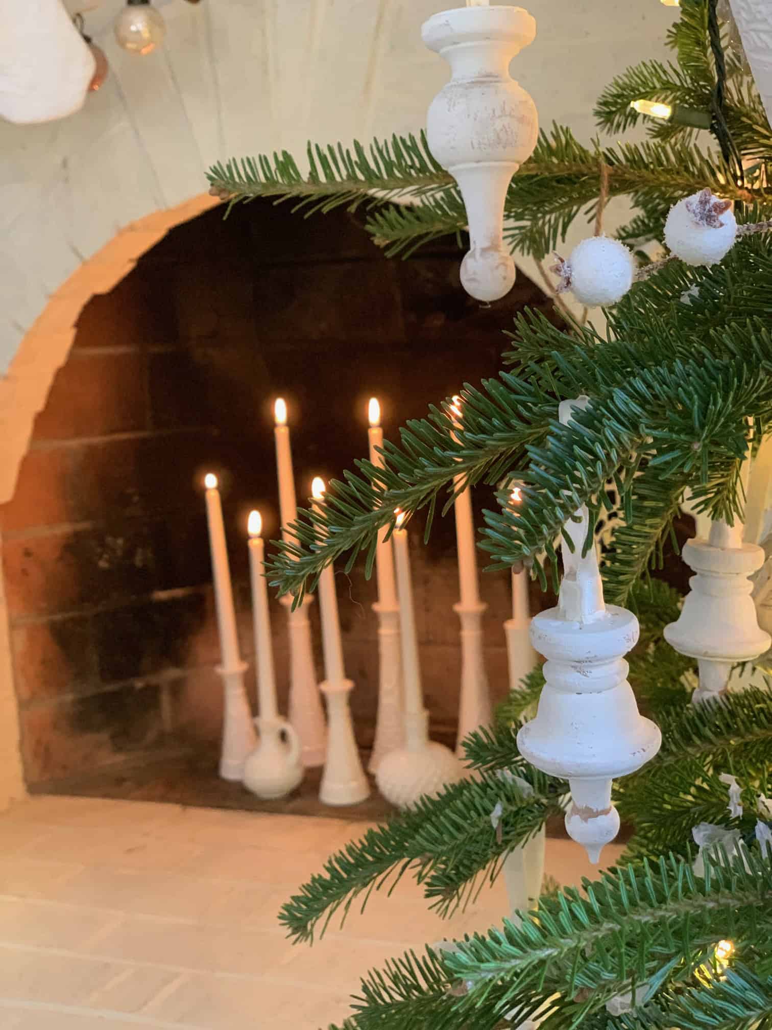 A Christmas display with white milk glass vases and candles. 