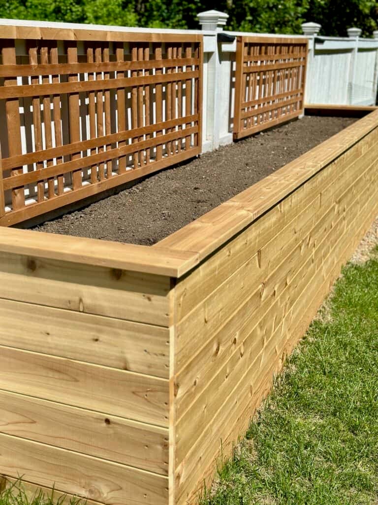 Raised herb garden bed filled with soil.