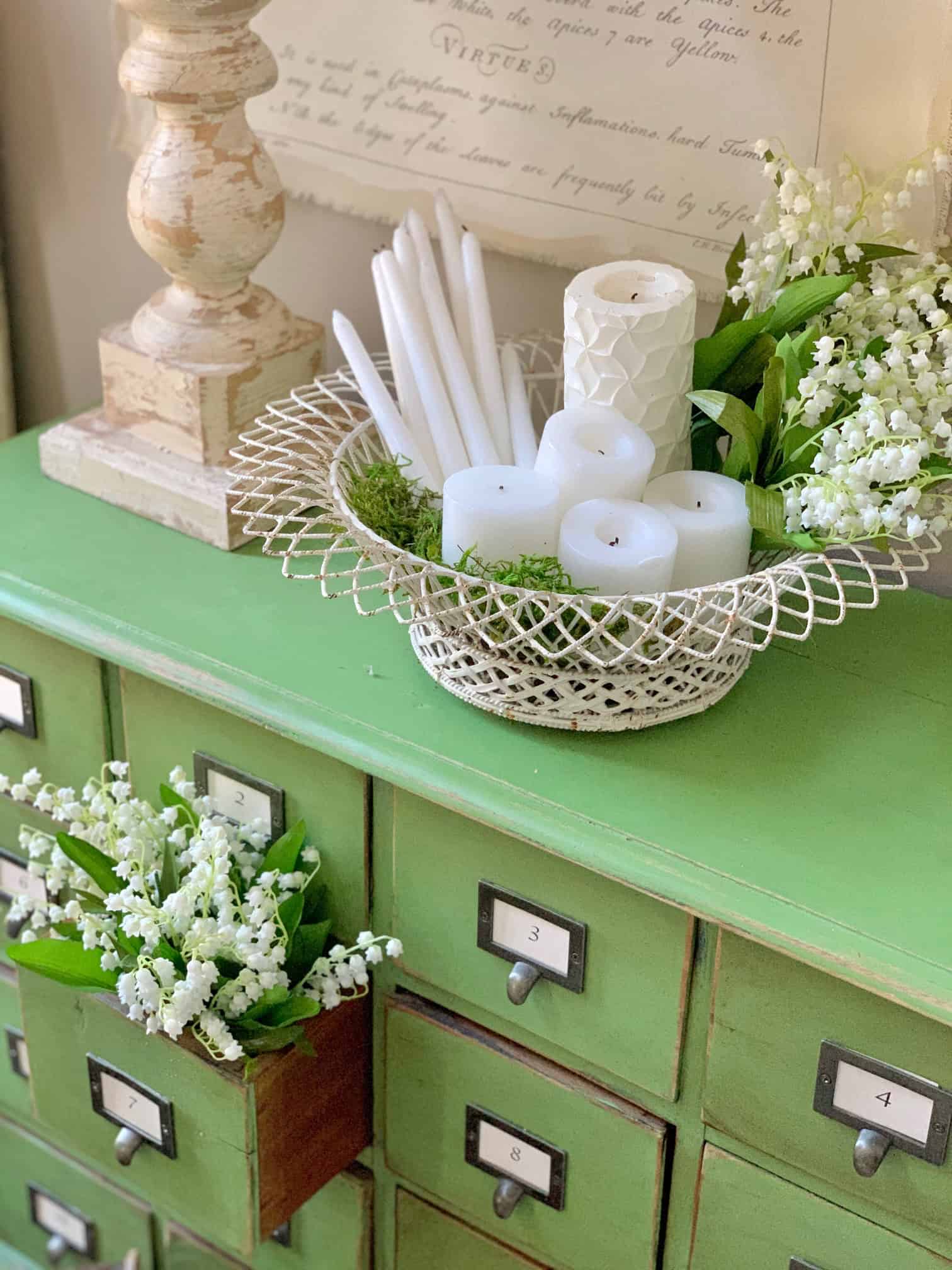 Green card catalog with a vintage wire bowl filled with candles. 