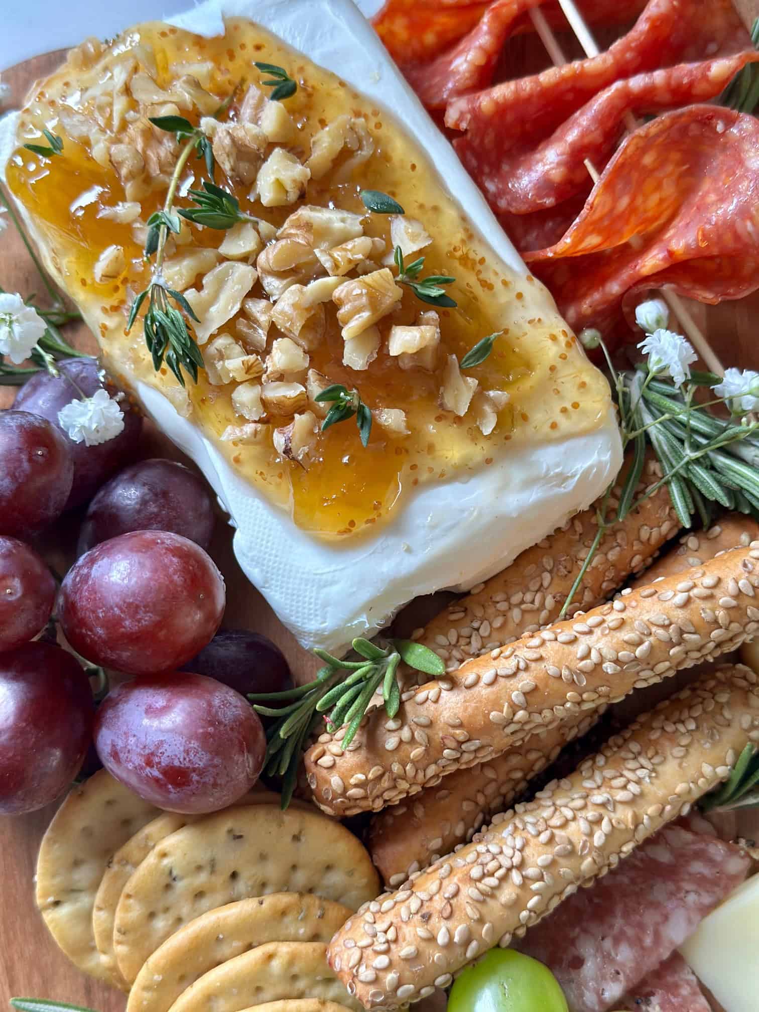 Cream cheese with fig jam and nuts on a charcuterie board. 