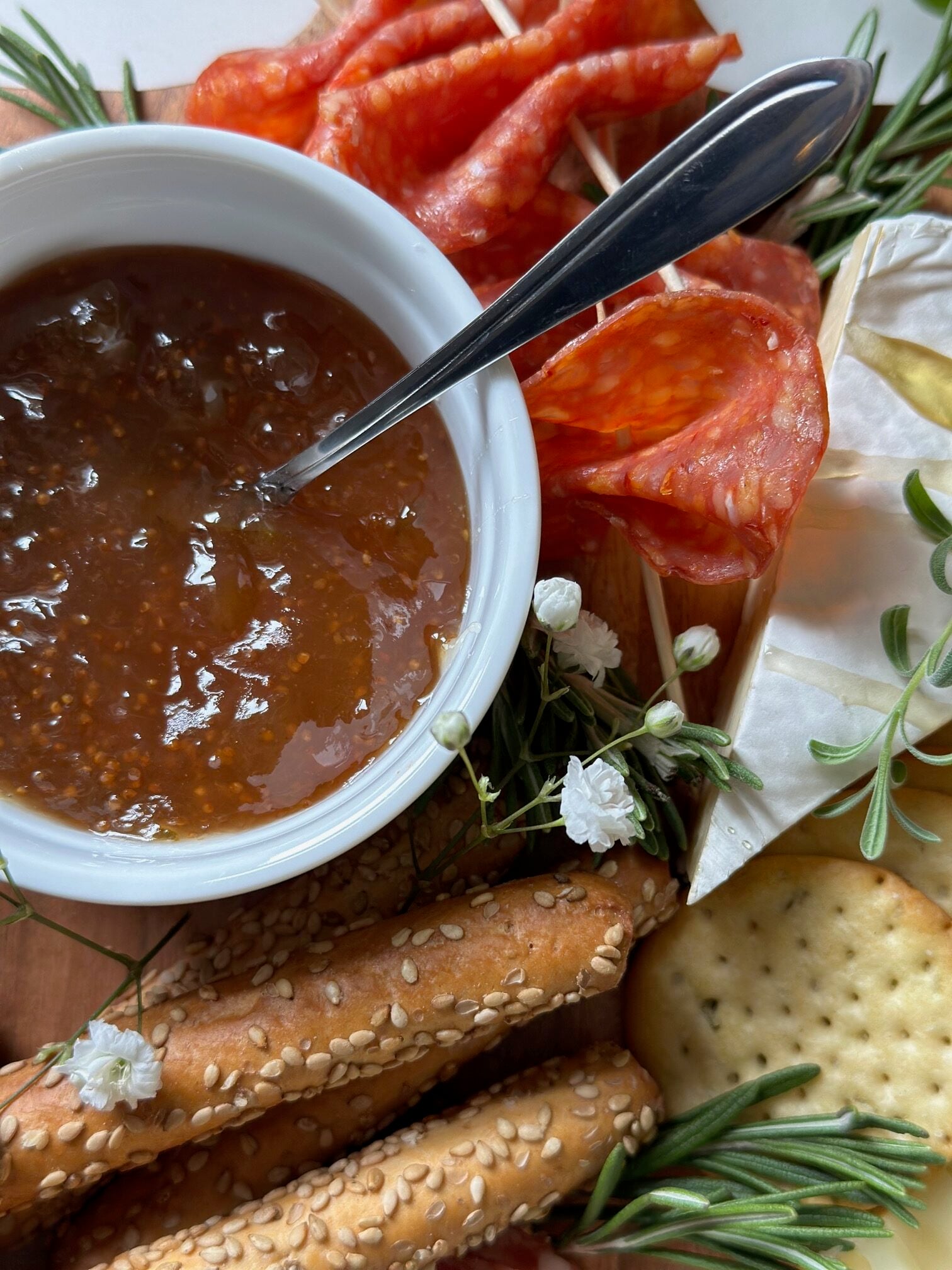 Fig jam in a small bowl on a charcuterie board. 
