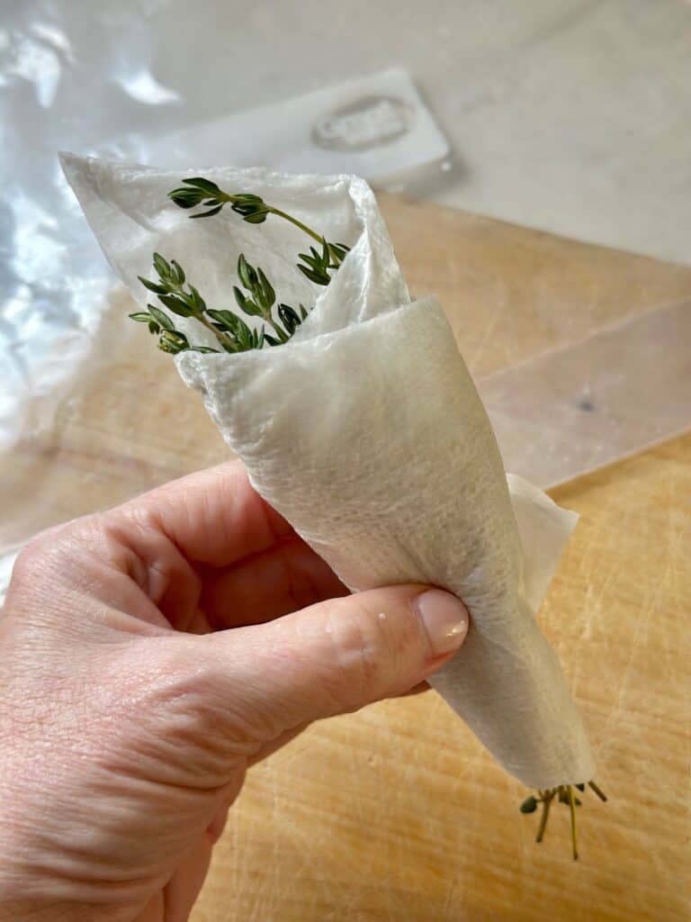 Thyme stems wrapped in a damp paper towel. 