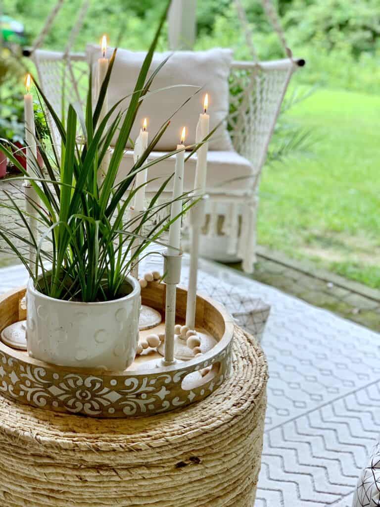 Wicker ottoman with tray, candles and plant. 